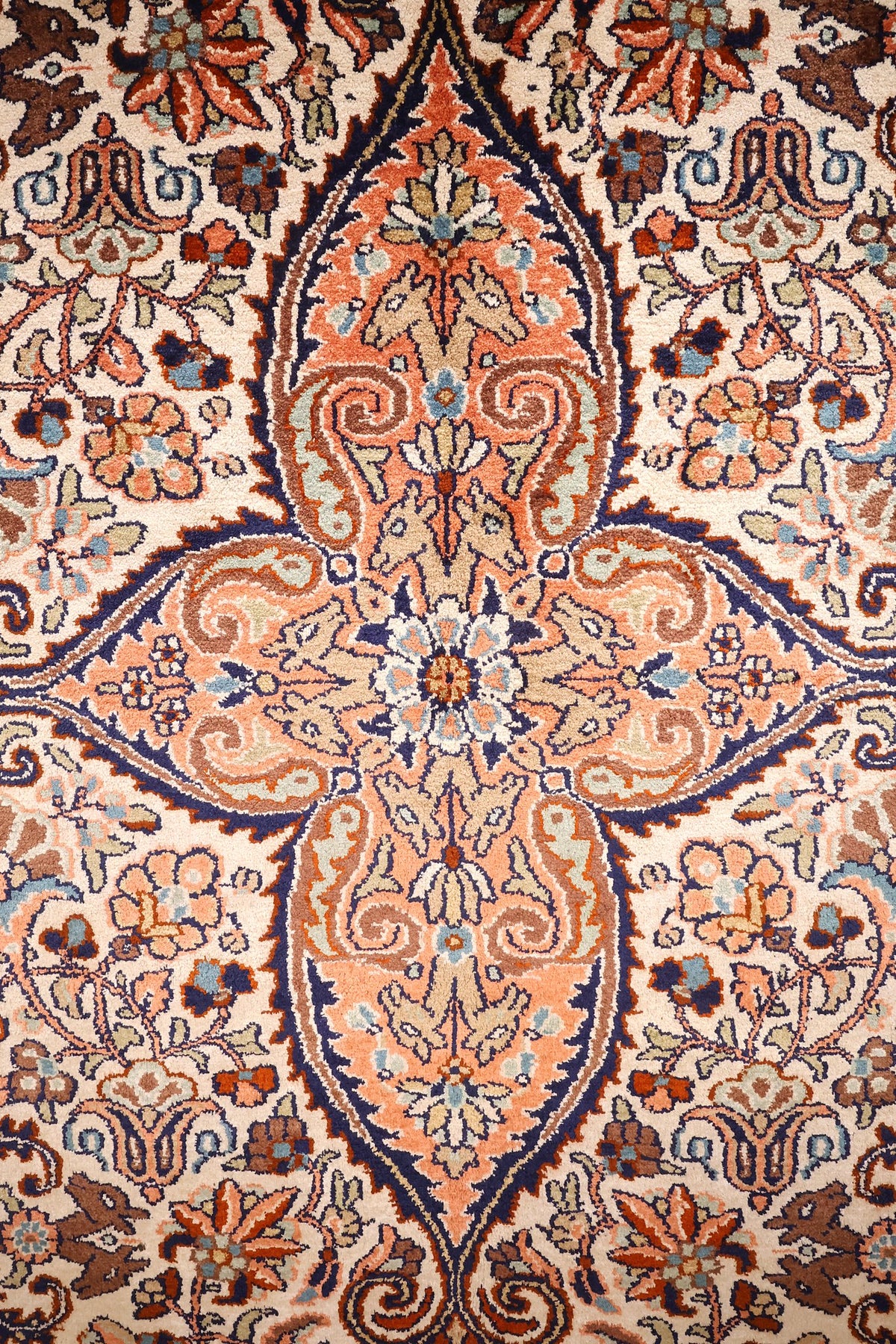 Détail du médaillon central à pendentifs orangés et boteh du tapis Cachemire
