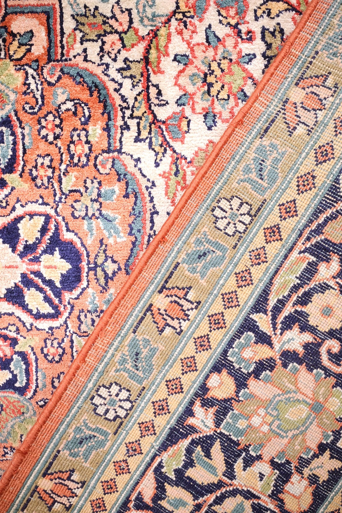 Envers du tapis Cachemire, nœuds serrés et lisière orangée le long de la bordure
