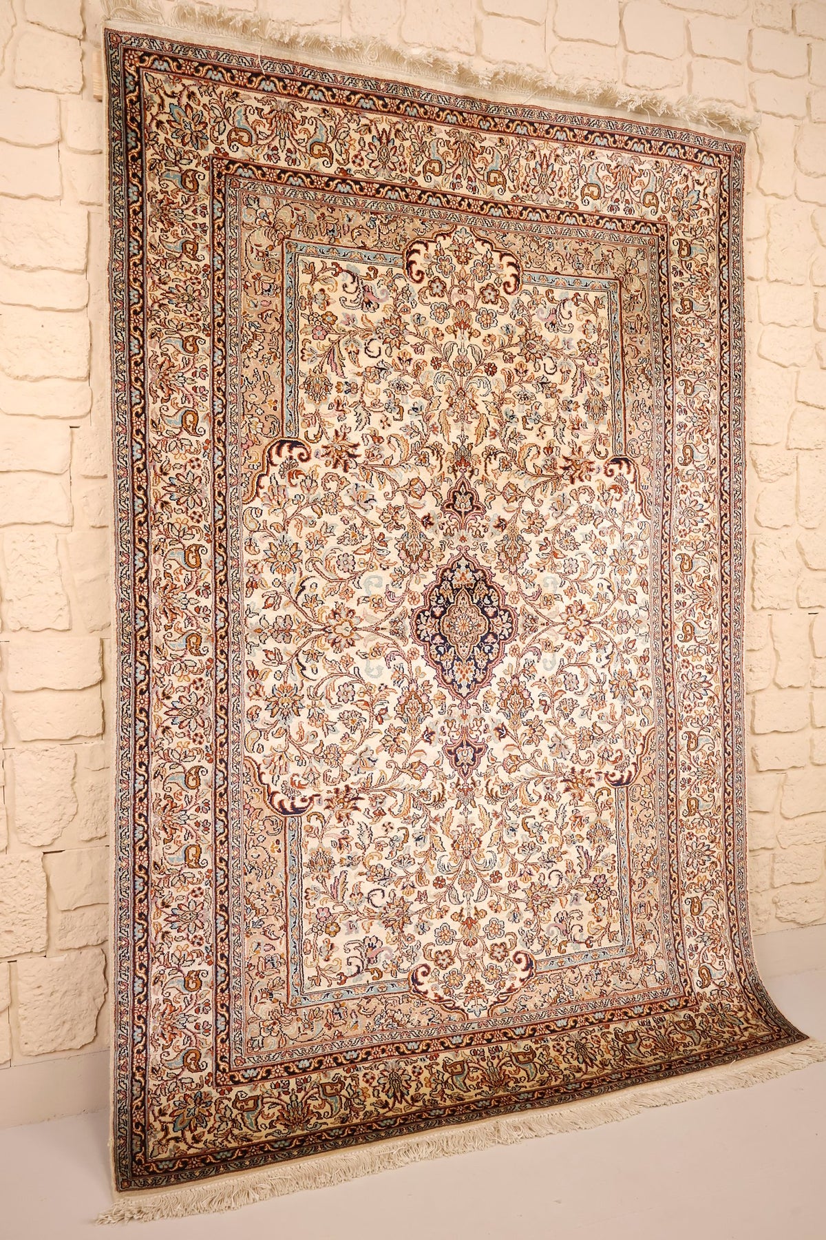 Vue de biais du tapis Cachemire beige et bleu, franges claires aux extrémités