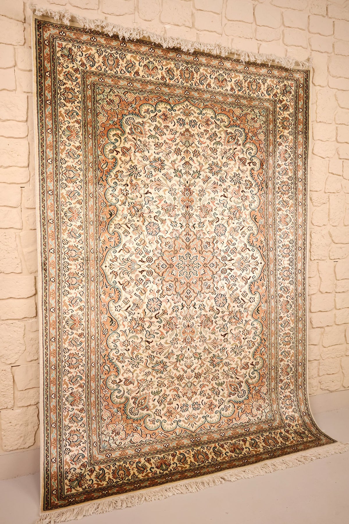Tapis Cachemire en soie beige et orange, vue de biais avec franges claires