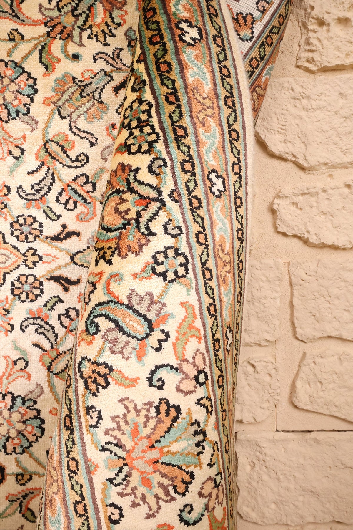 Lisière du tapis Cachemire beige, bordure florale aux tons orangés et verts