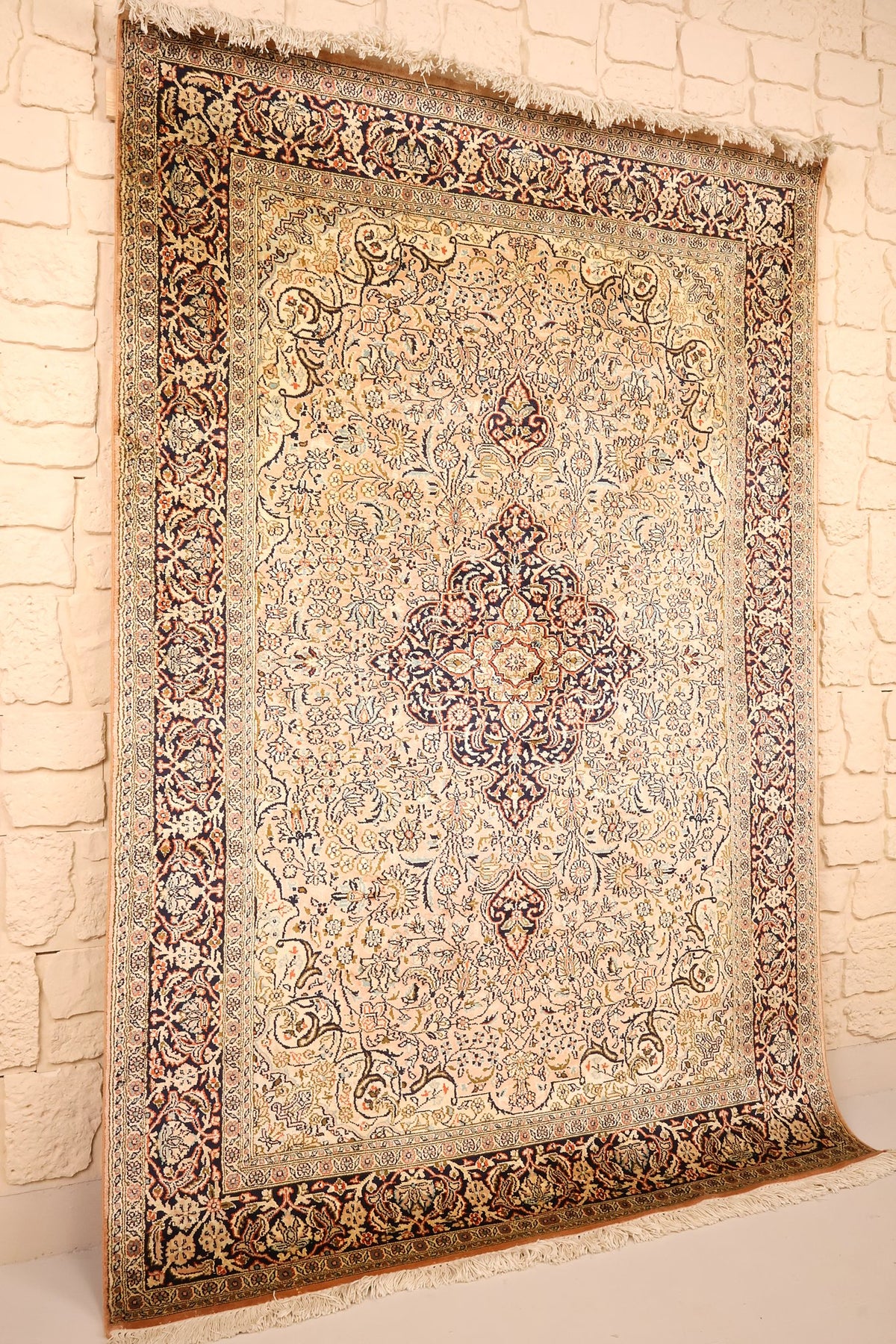 Vue de biais du tapis Cachemire beige et bleu, franges claires aux deux extrémités