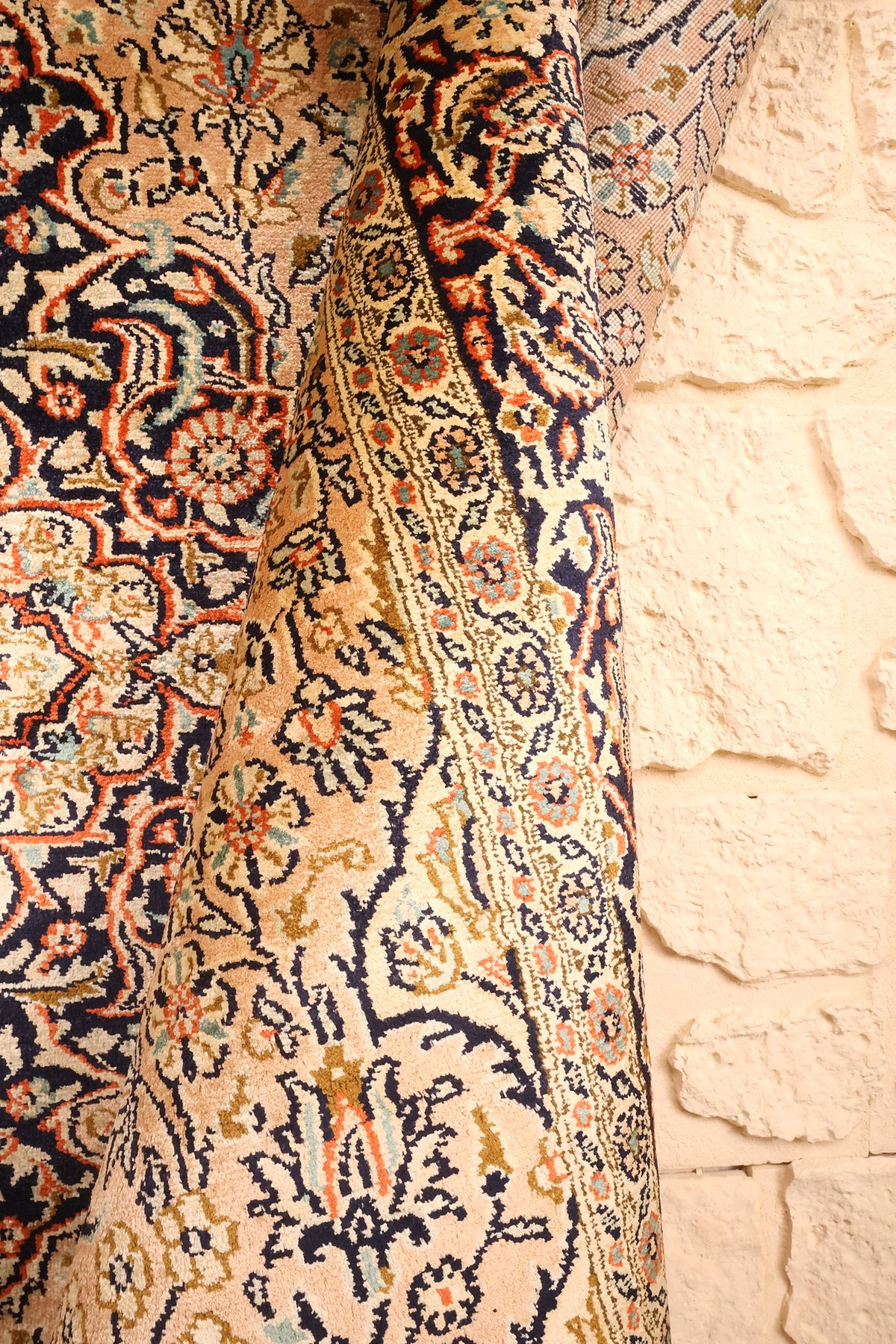 Tapis Cachemire beige rosé plié, souplesse de la soie nouée main