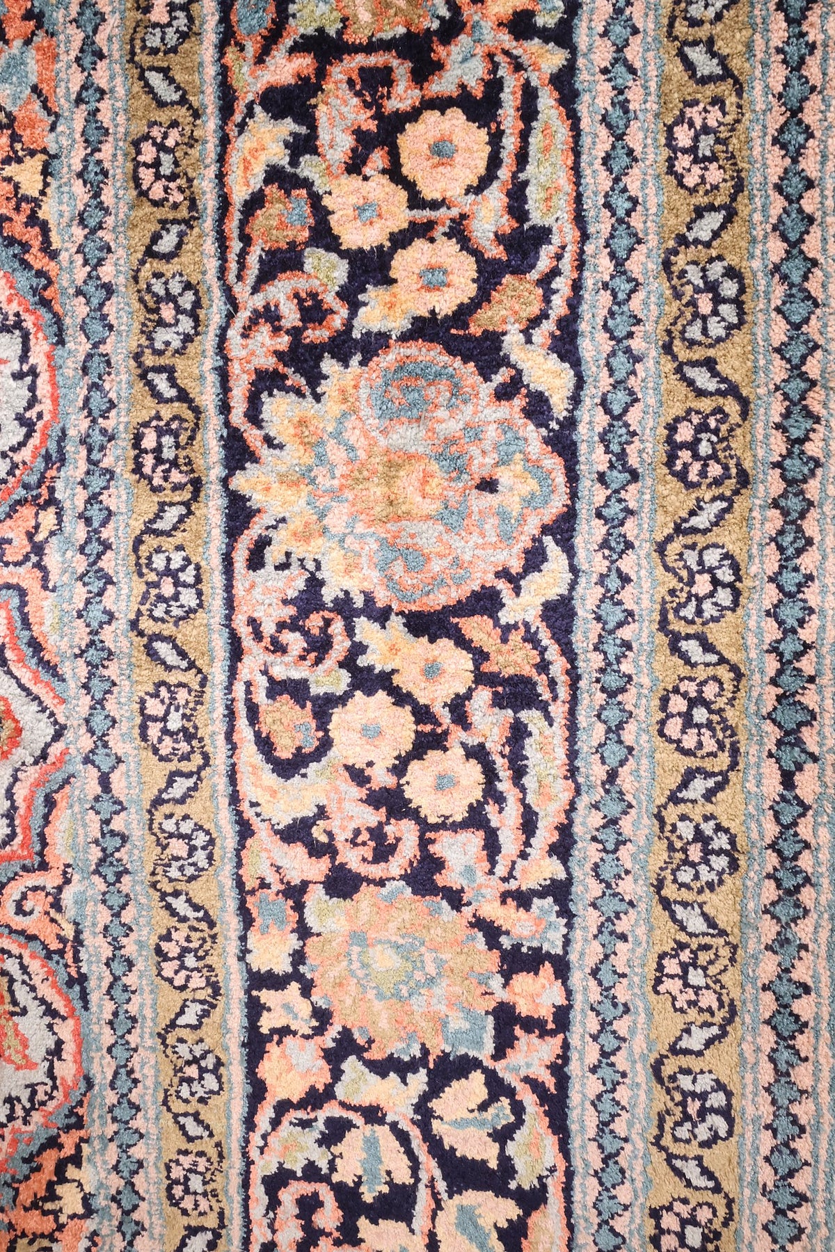 Bordure bleu nuit à fleurs orange et contre-bordures rose et or du tapis Cachemire