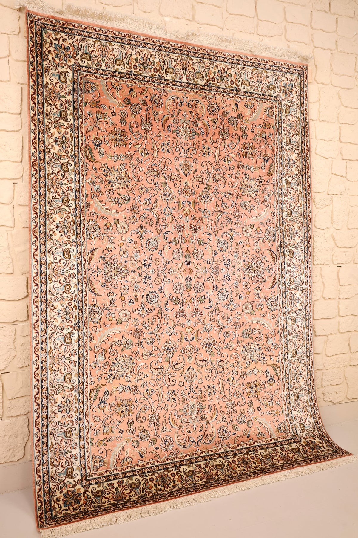 Tapis Cachemire rose et ivoire vu de biais, franges claires aux extrémités