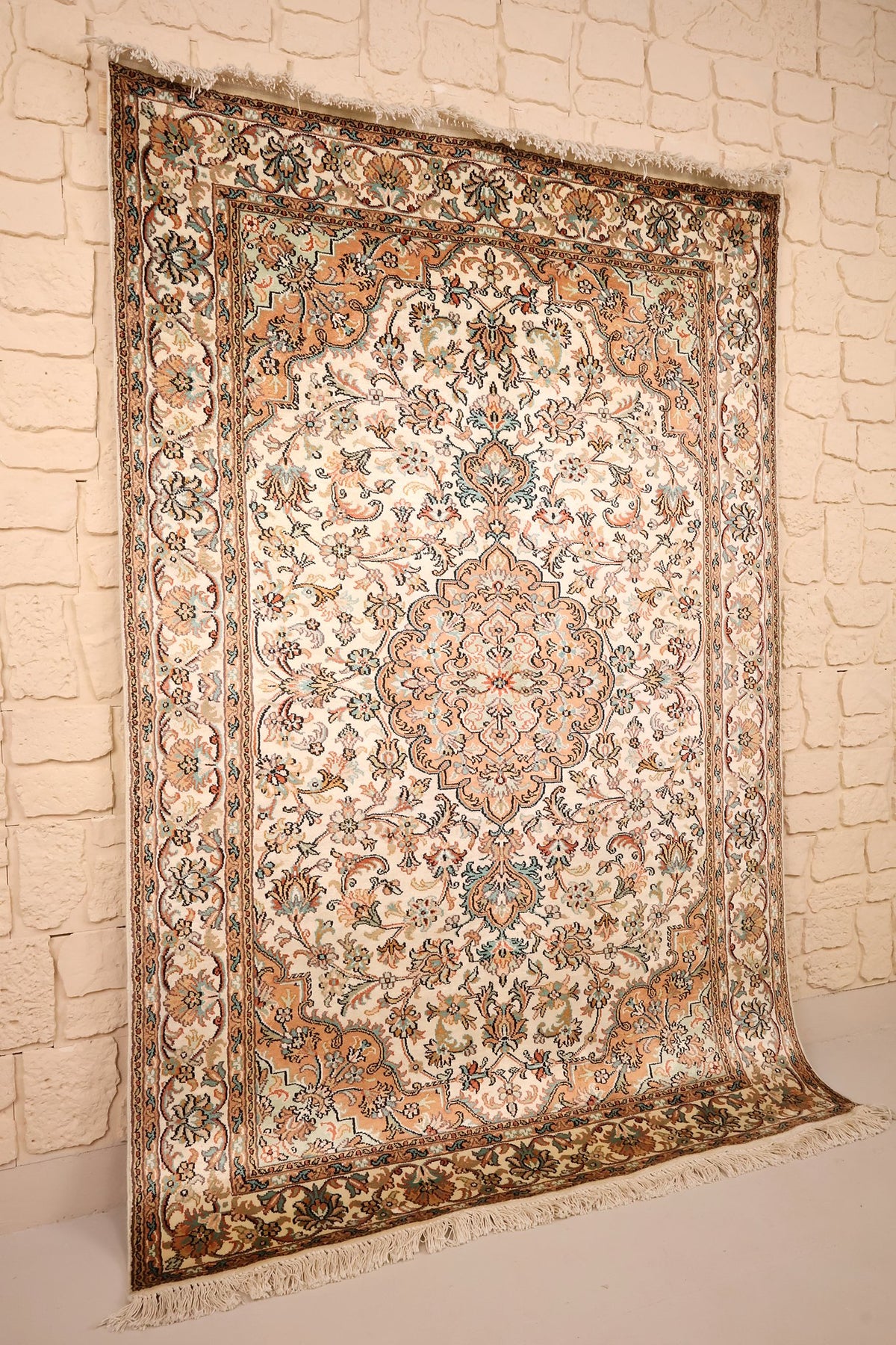 Tapis Cachemire en soie beige et orange, vue de biais montrant les franges