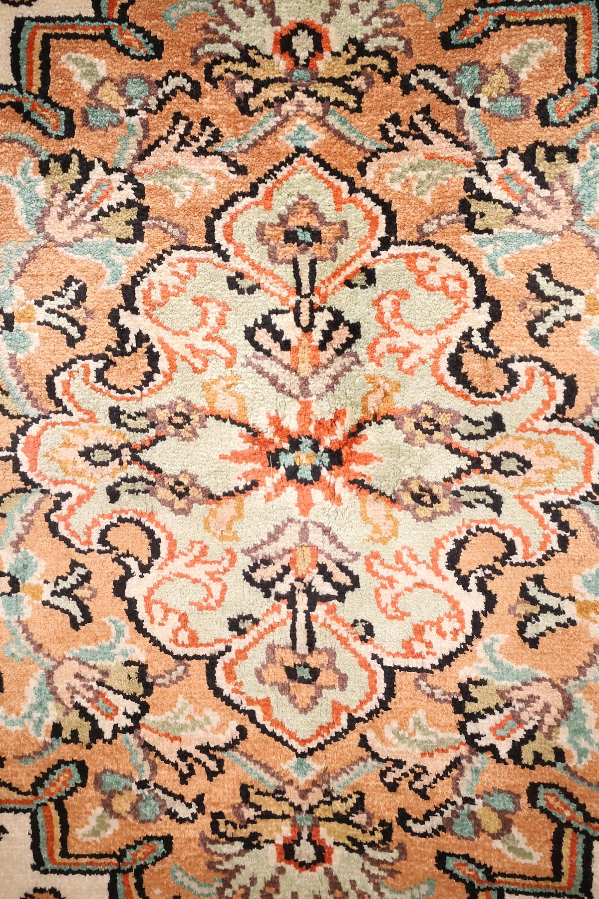 Détail du médaillon losangé vert d'eau et orange du tapis Cachemire