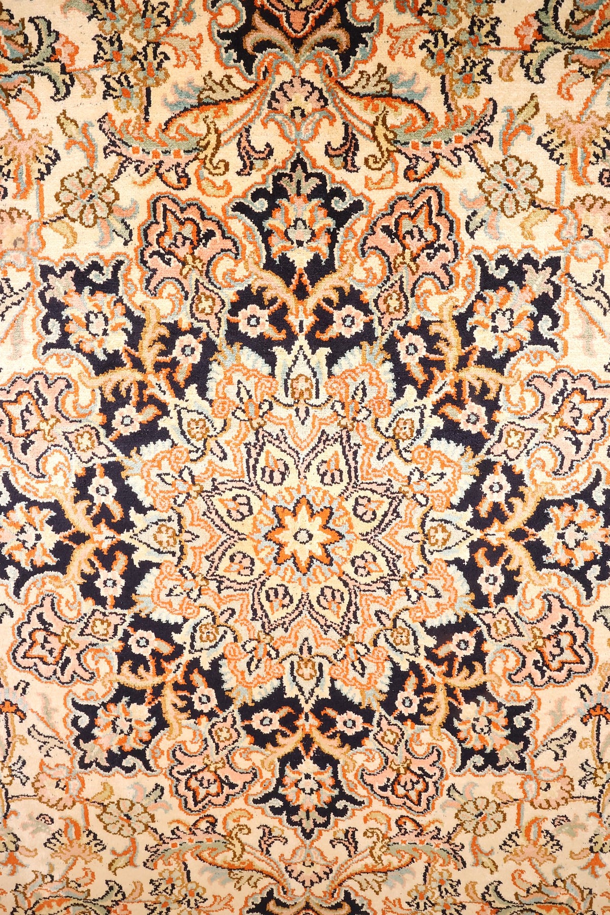 Détail du médaillon central étoilé orange et bleu nuit du tapis Cachemire