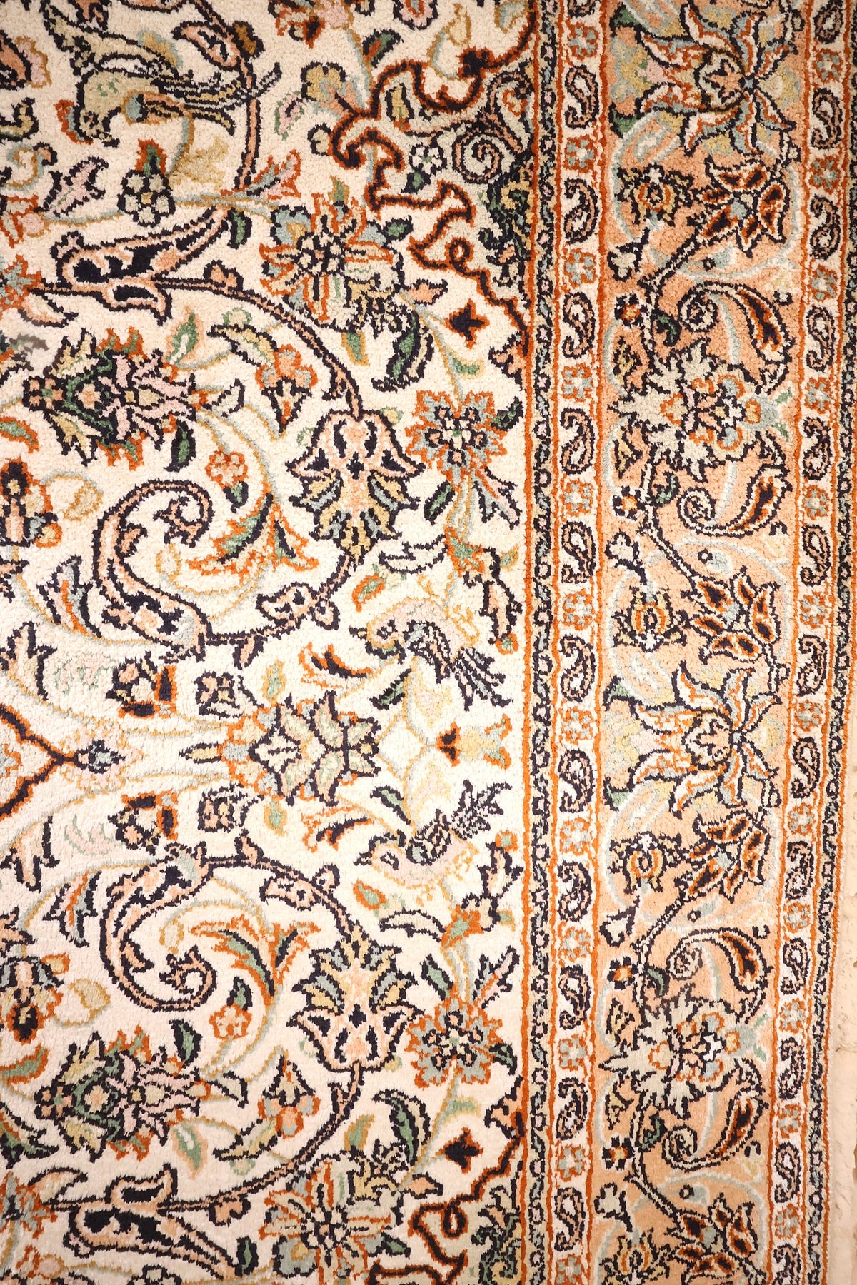 Bordure à boteh et fleurs sur fond saumon, encadrée de contre-bordures étroites
