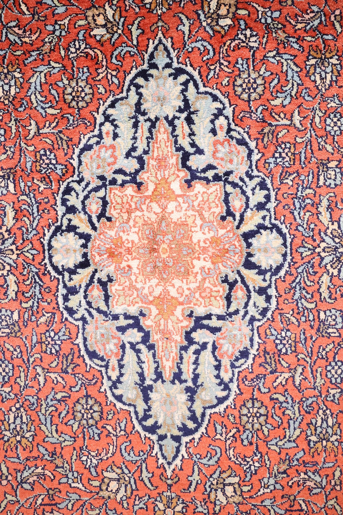Détail du médaillon à cœur ivoire et orange cerné de bleu nuit, tapis Cachemire rouge