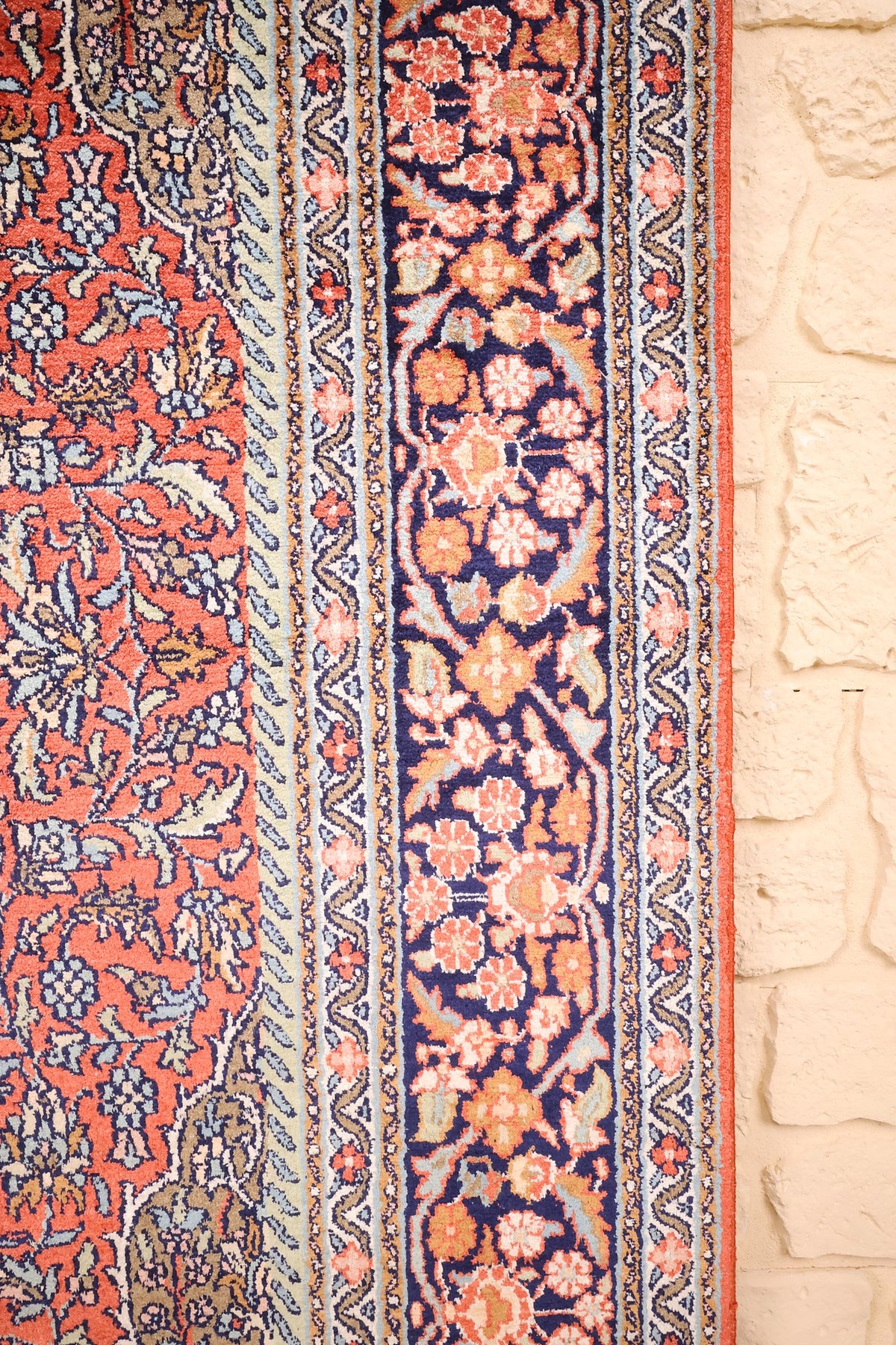 Bordure bleu nuit à fleurs et palmettes orange du tapis Cachemire, contre-bordures étroites