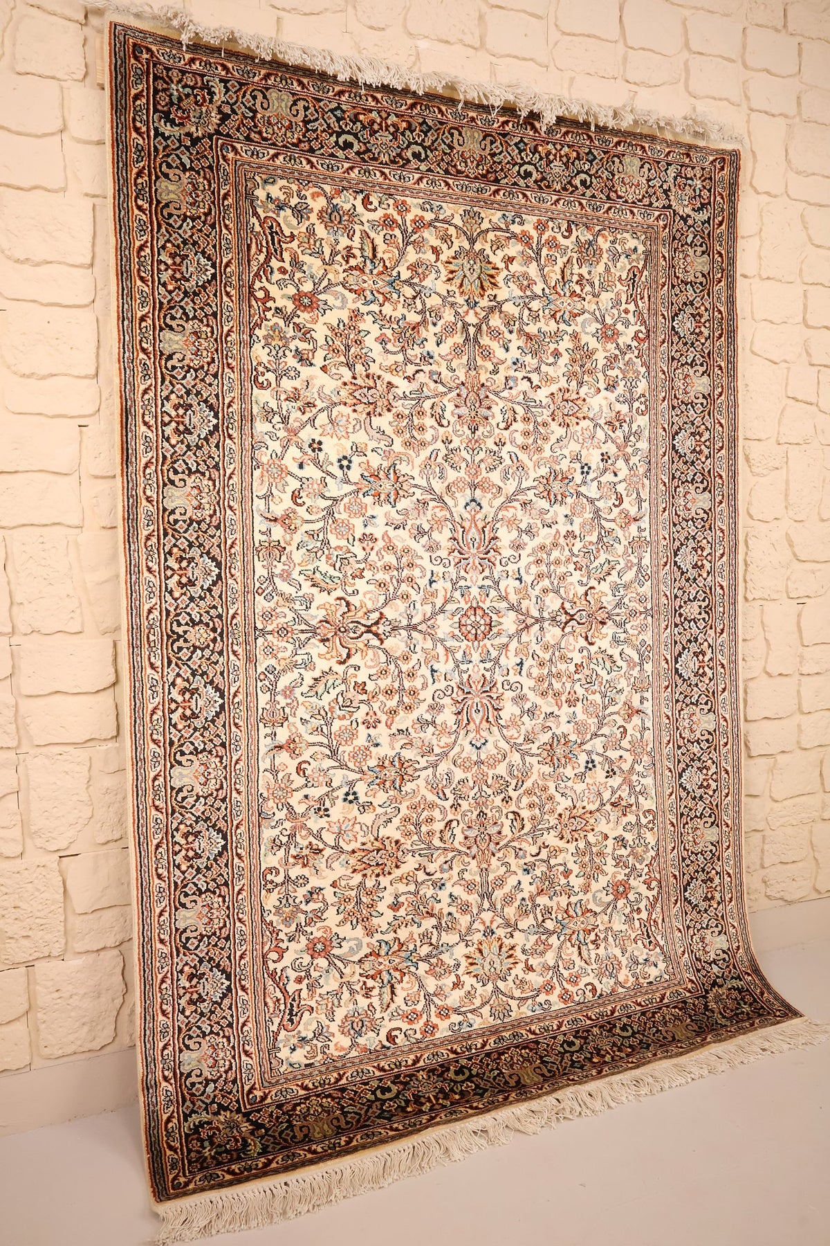 Tapis Cachemire beige et noir vu de biais, franges écrues visibles