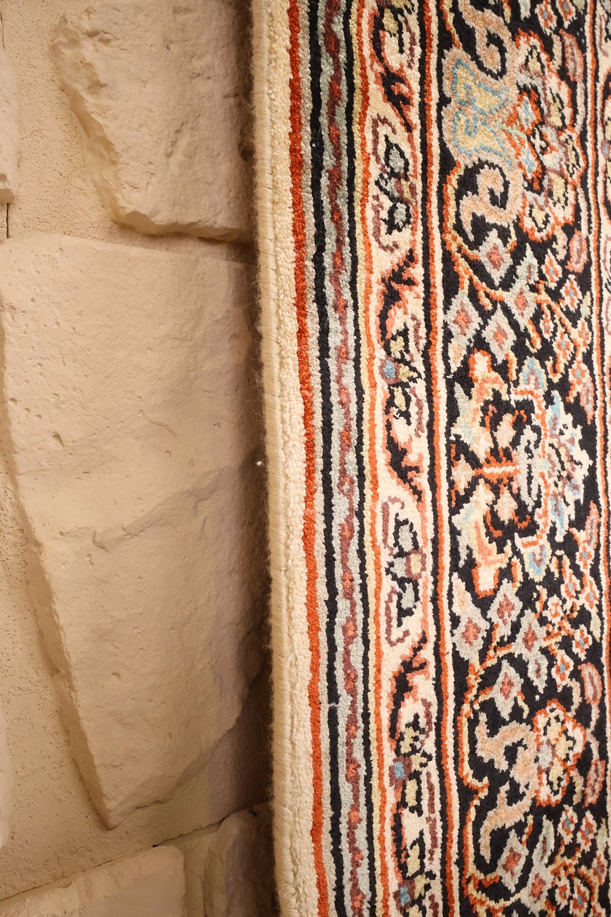 Lisière écrue et filets orange du tapis Cachemire beige, vue rapprochée