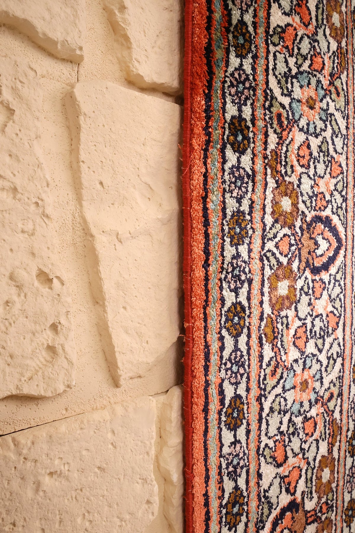 Lisière orange du tapis Cachemire en soie, bordure beige rosé en bord de mur