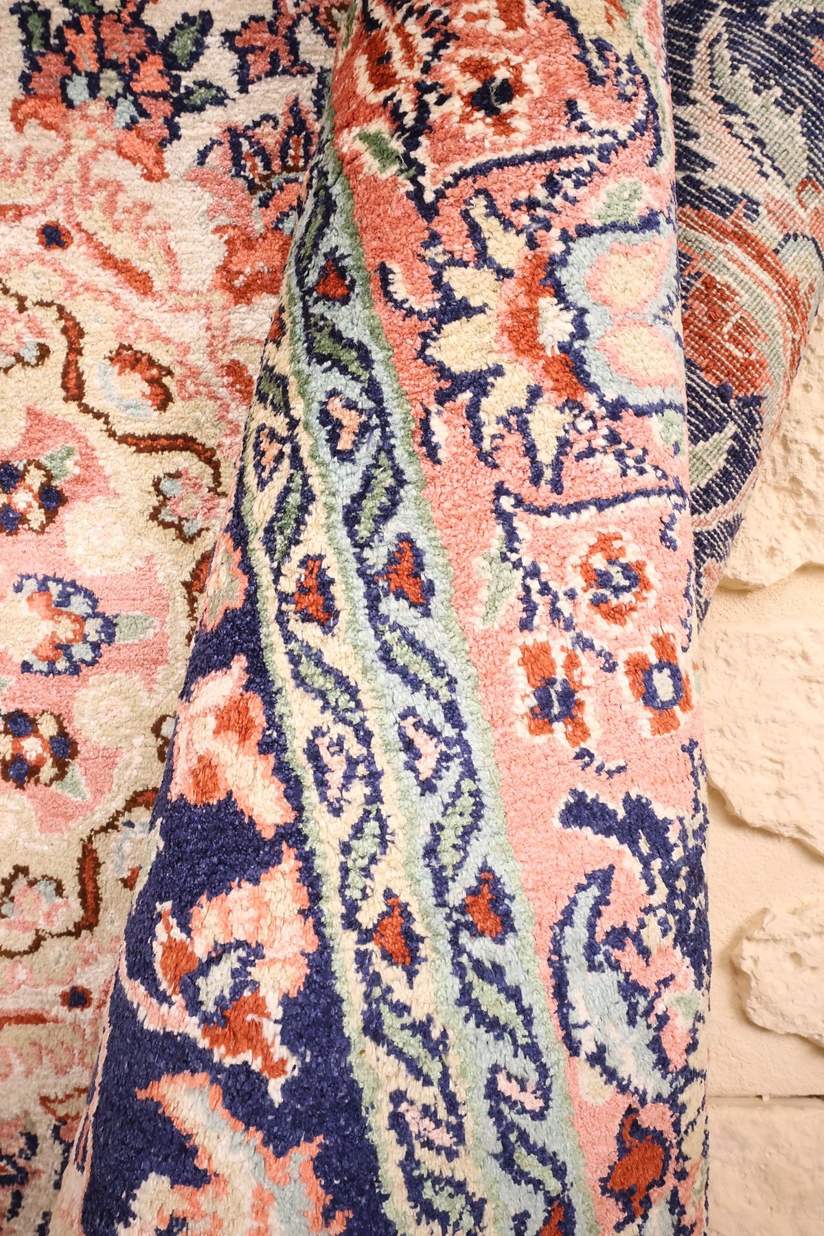Coin replié du tapis Cachemire 185 × 122 cm, décor floral rose et bleu