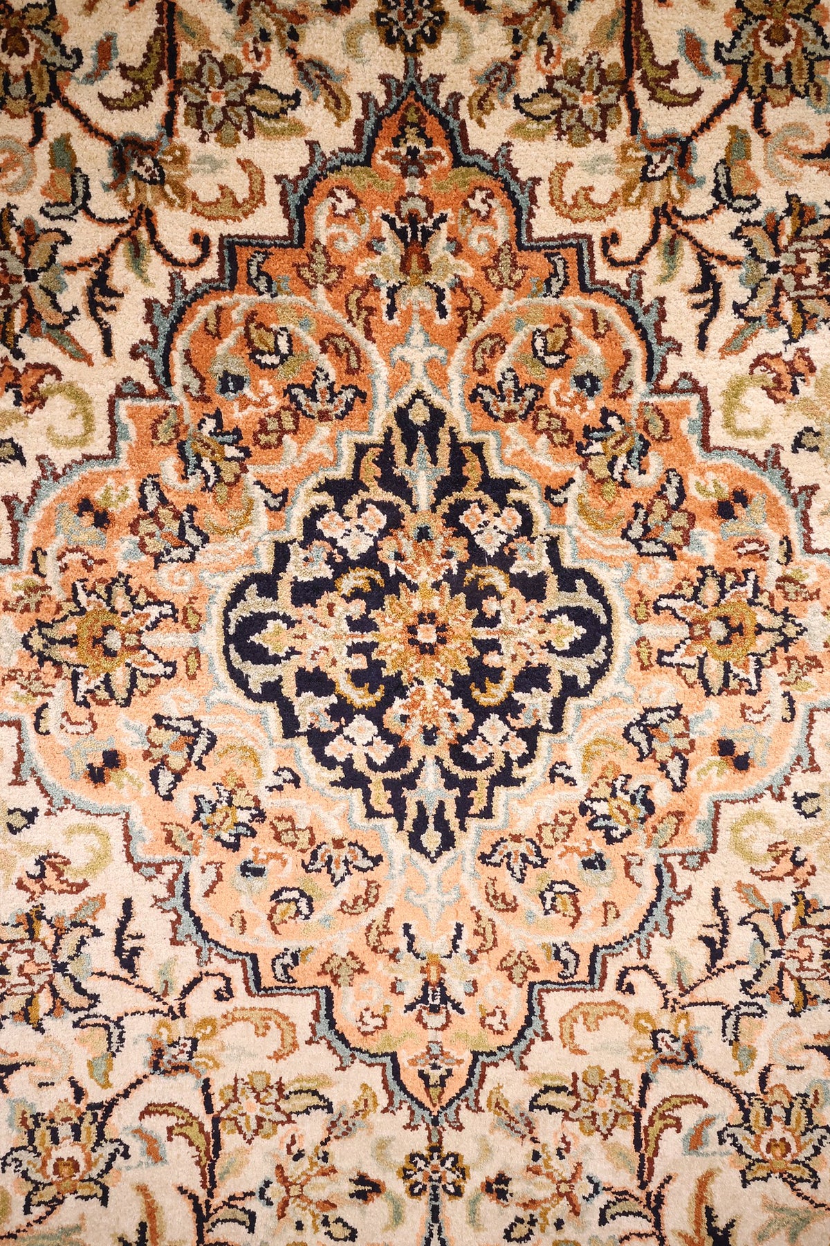 Détail du médaillon orange à cœur bleu nuit du tapis Cachemire en soie