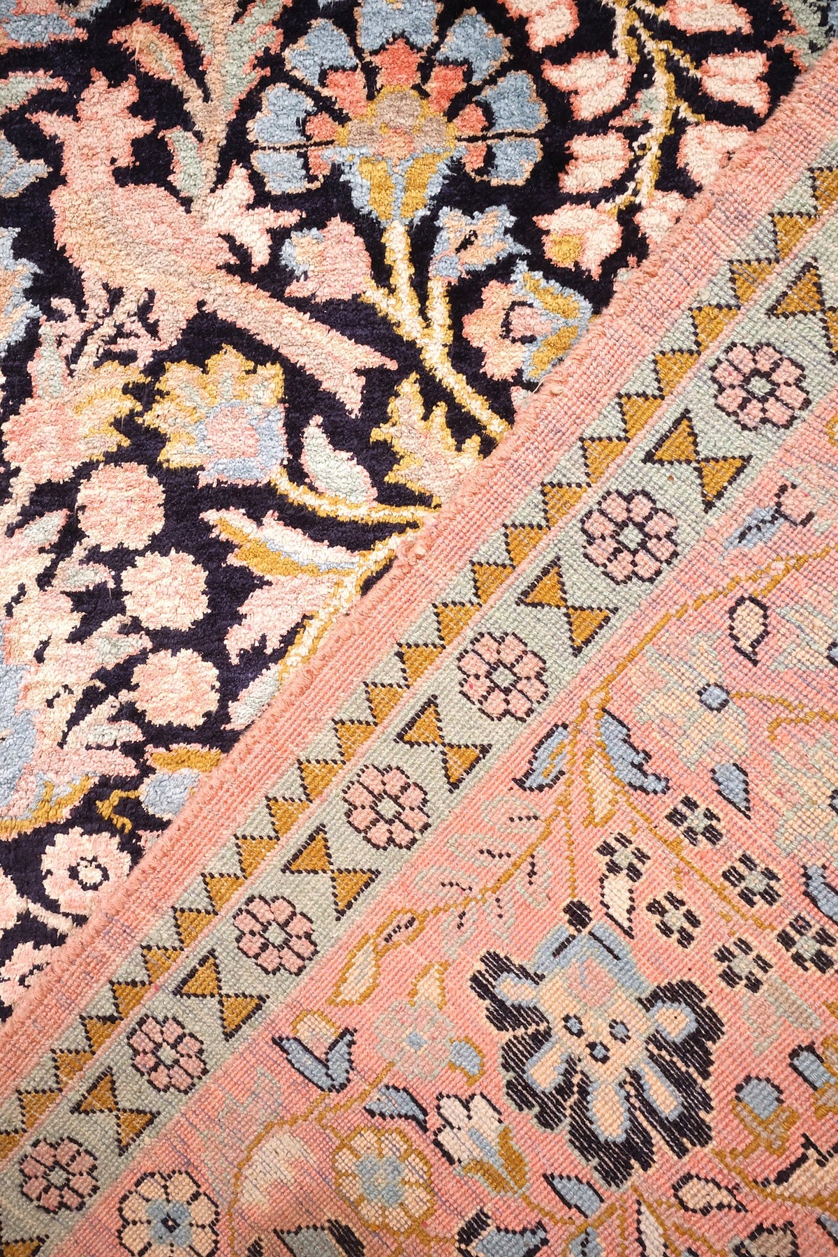 Coin du tapis Cachemire, chevrons jaunes et petites rosettes entre champ et bordure