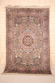 Tapis Cachemire en soie, vue de face du champ beige rosé fleuri et de ses écoinçons sombres