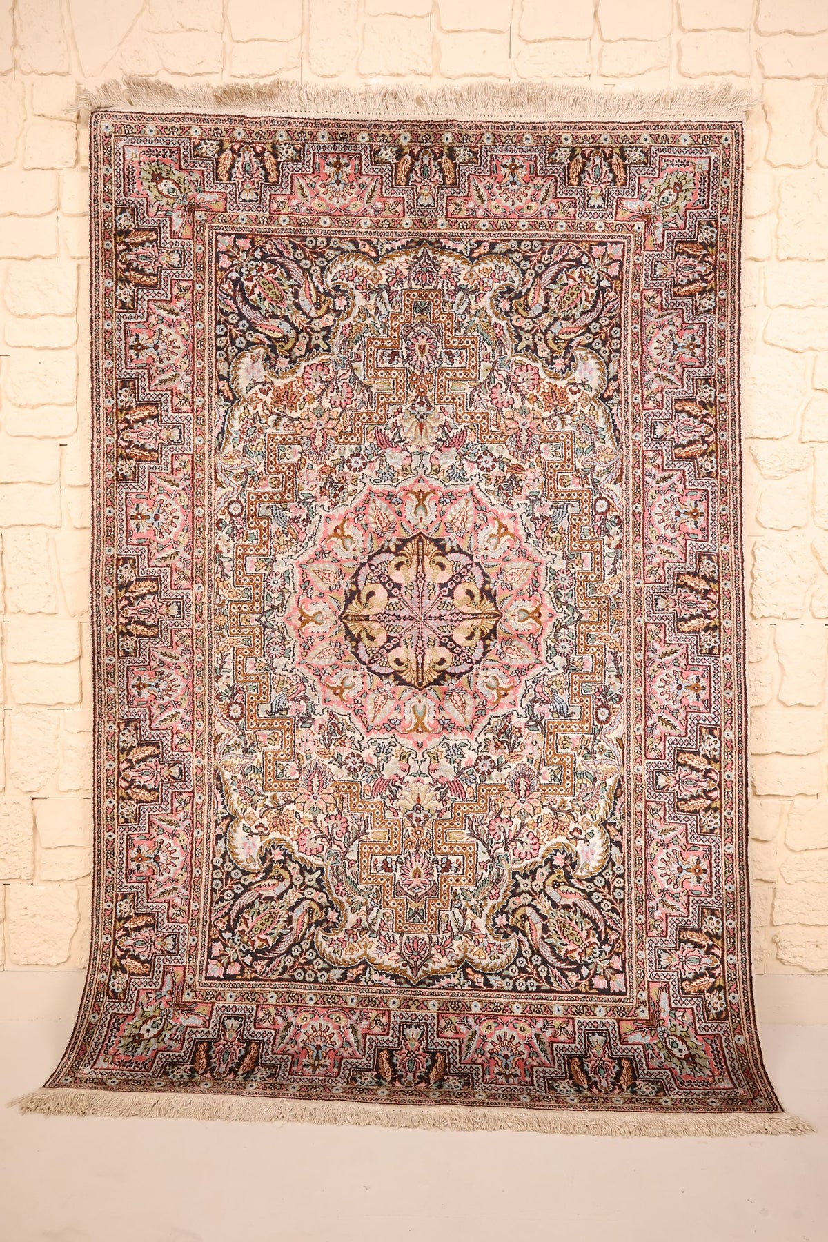 Tapis Cachemire en soie, vue de face du champ beige rosé fleuri et de ses écoinçons sombres
