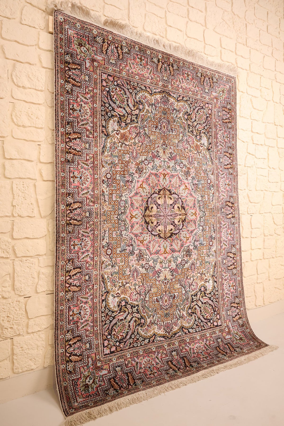 Vue de biais du tapis Cachemire rose et beige noué à la main