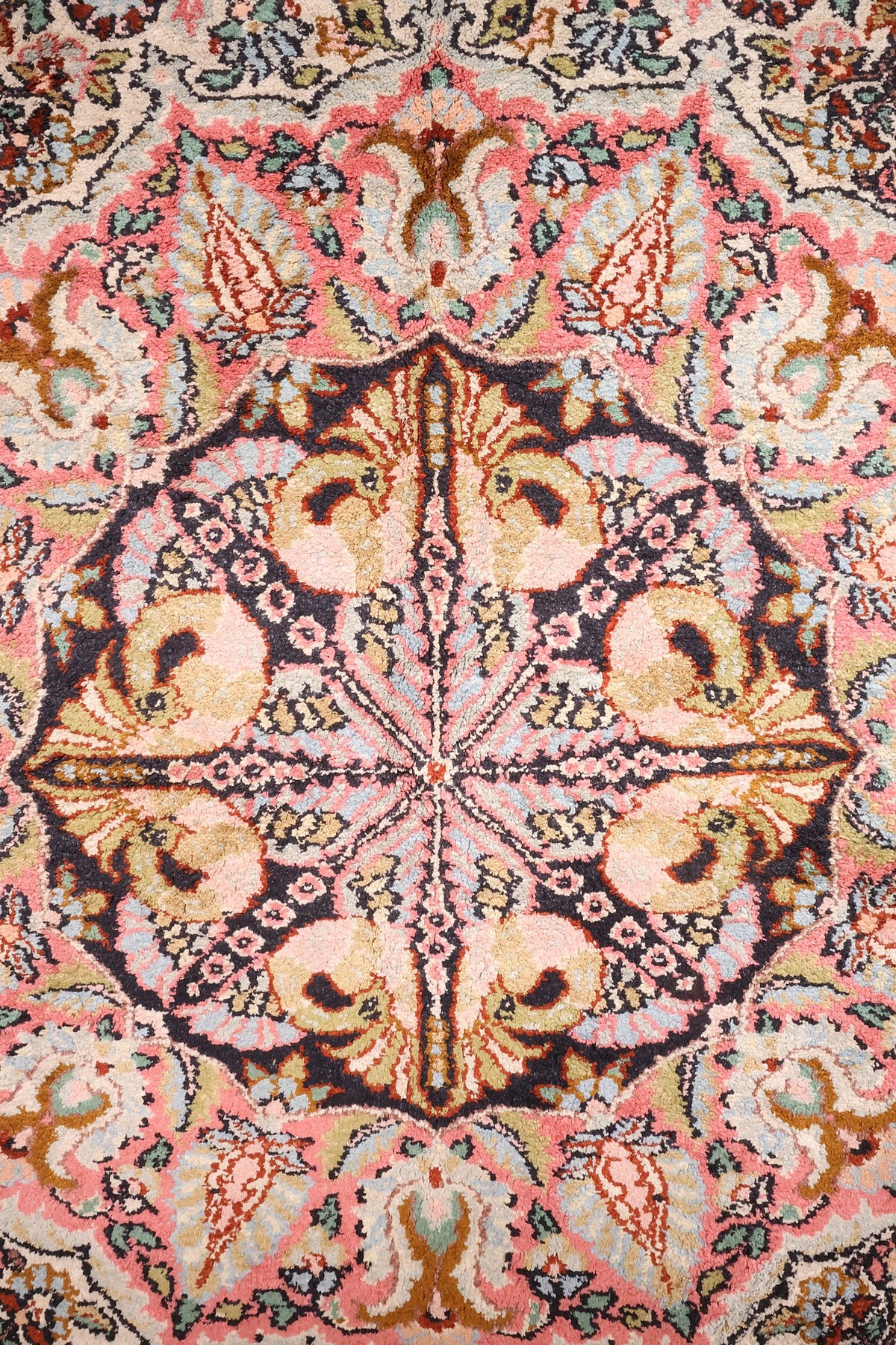 Détail du médaillon en étoile sur fond bleu nuit, couronne rose du tapis Cachemire