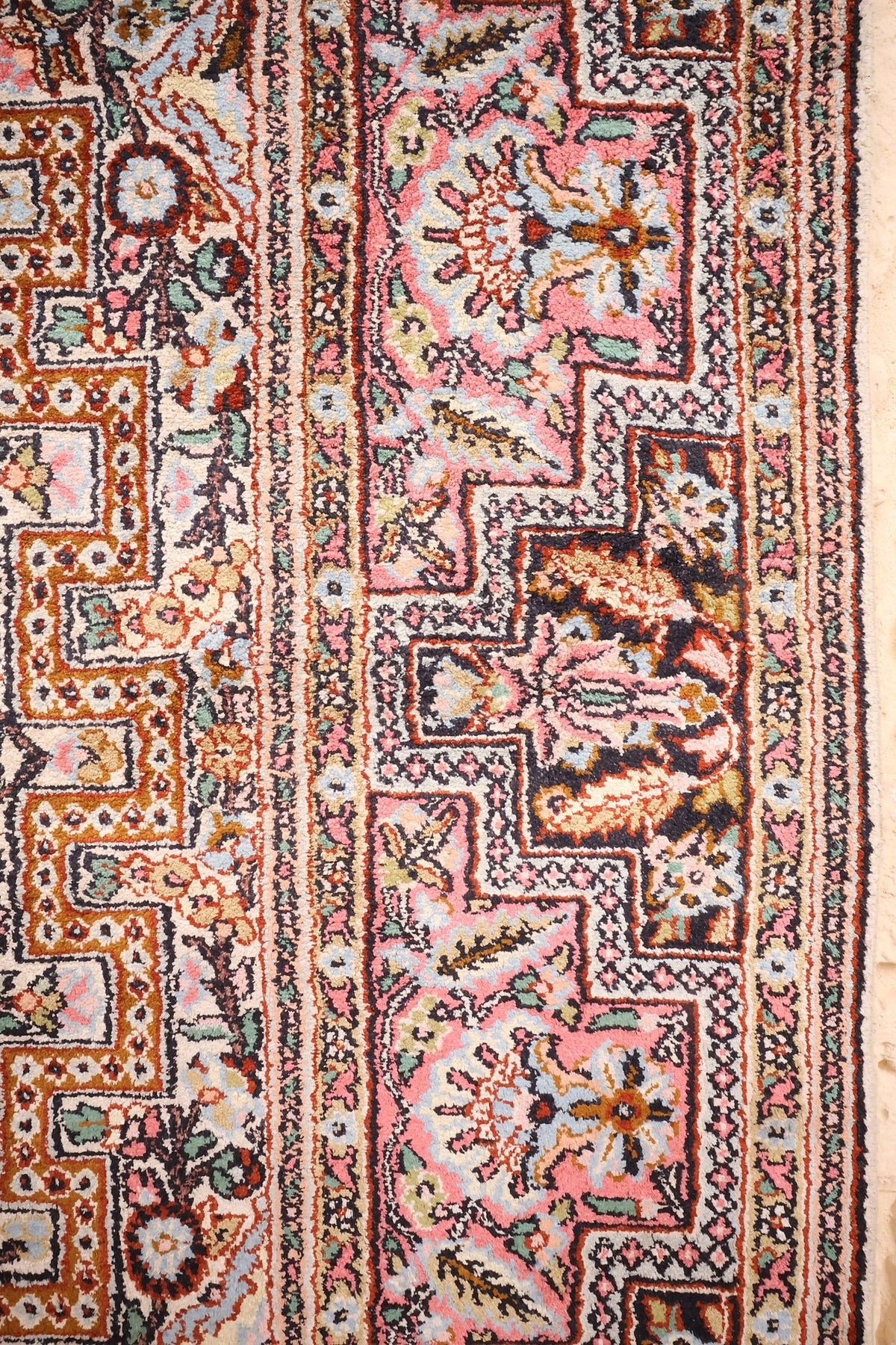Bordure rose à palmettes et contre-bordures ivoire et brunes du tapis Cachemire