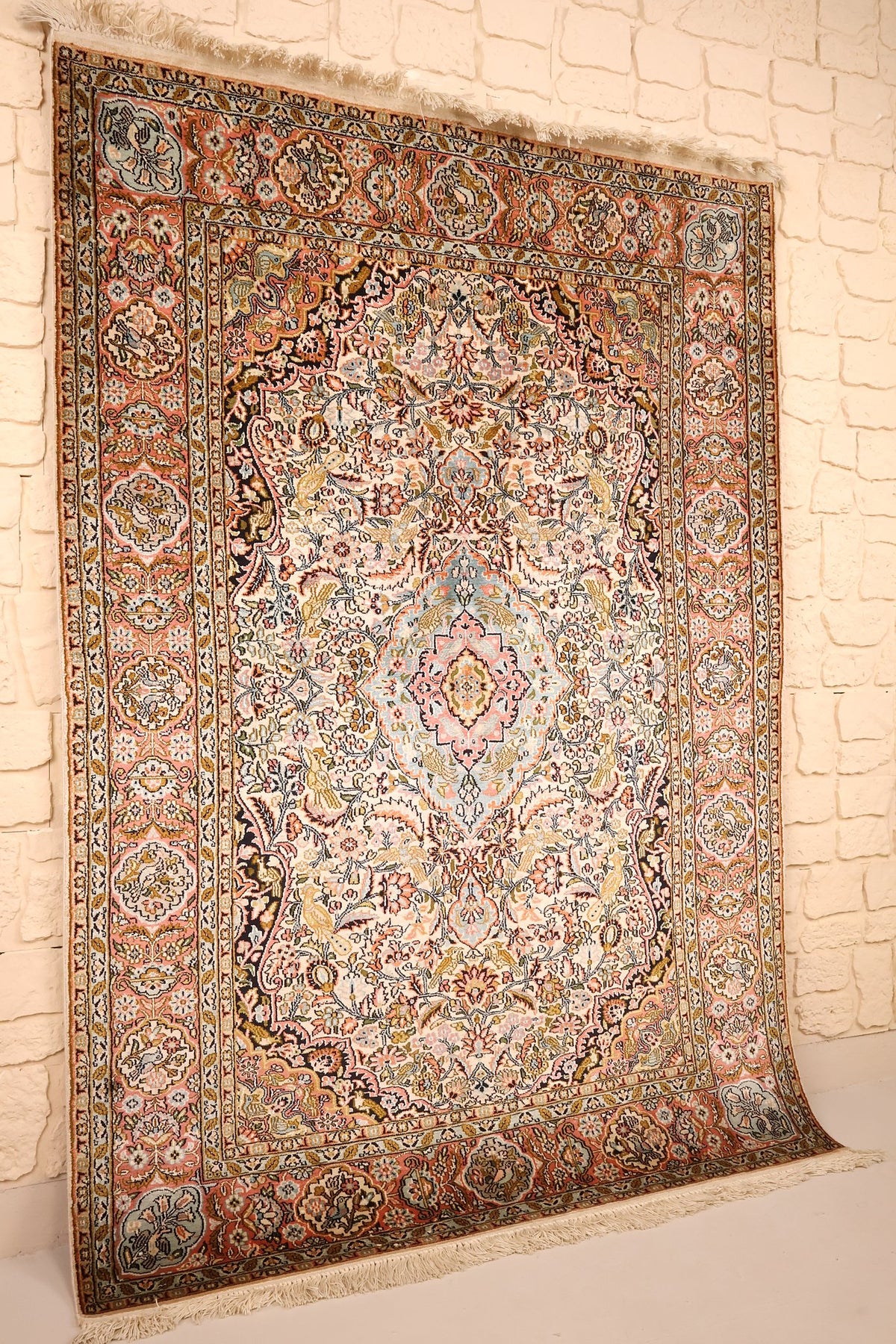 Tapis Cachemire beige et rose vu de biais, bordure saumon et franges claires