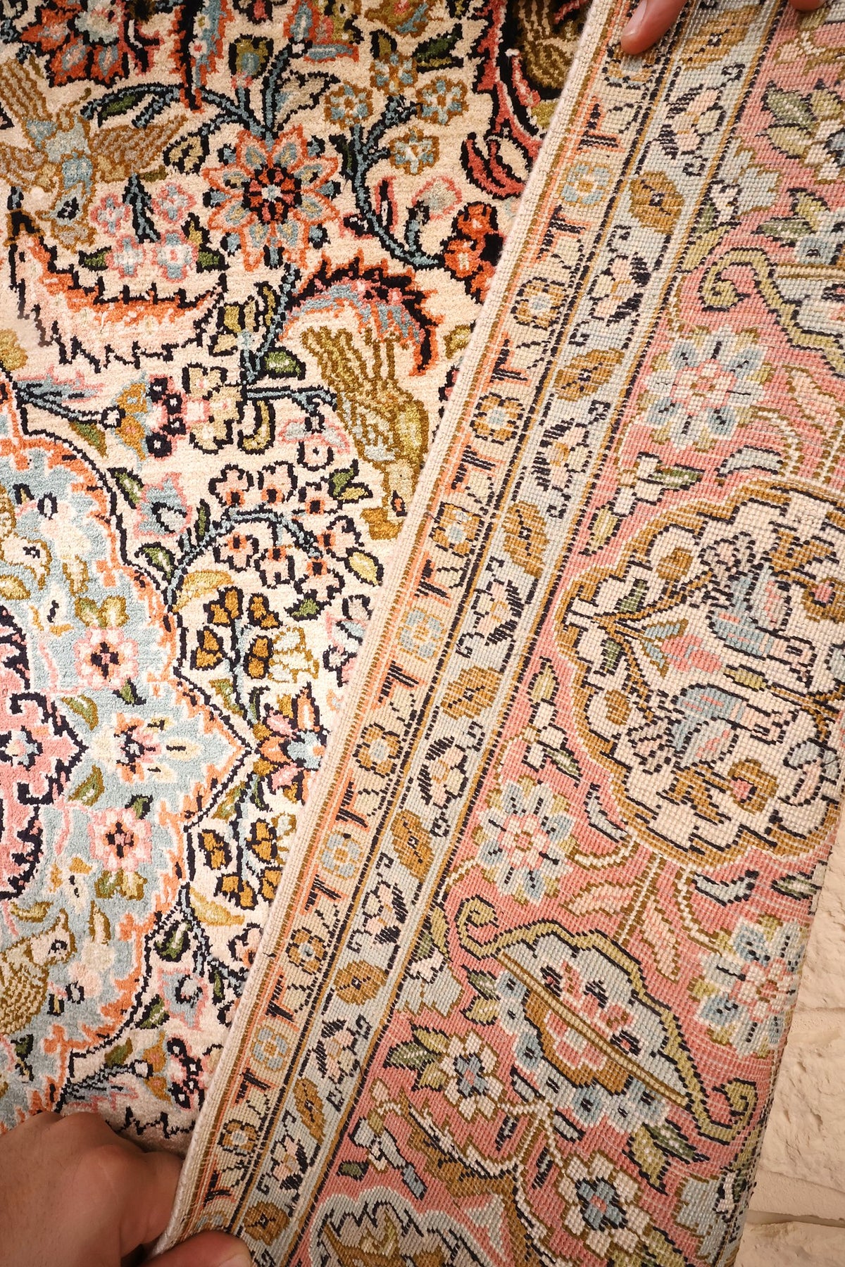 Coin replié du tapis Cachemire en soie, finesse des nœuds visible à l'envers
