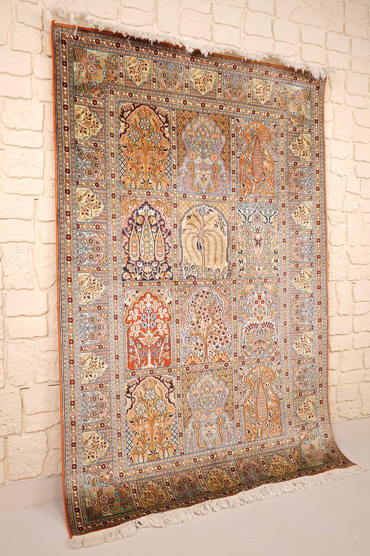 Tapis Cachemire en soie beige et orange, vue de biais avec franges blanches