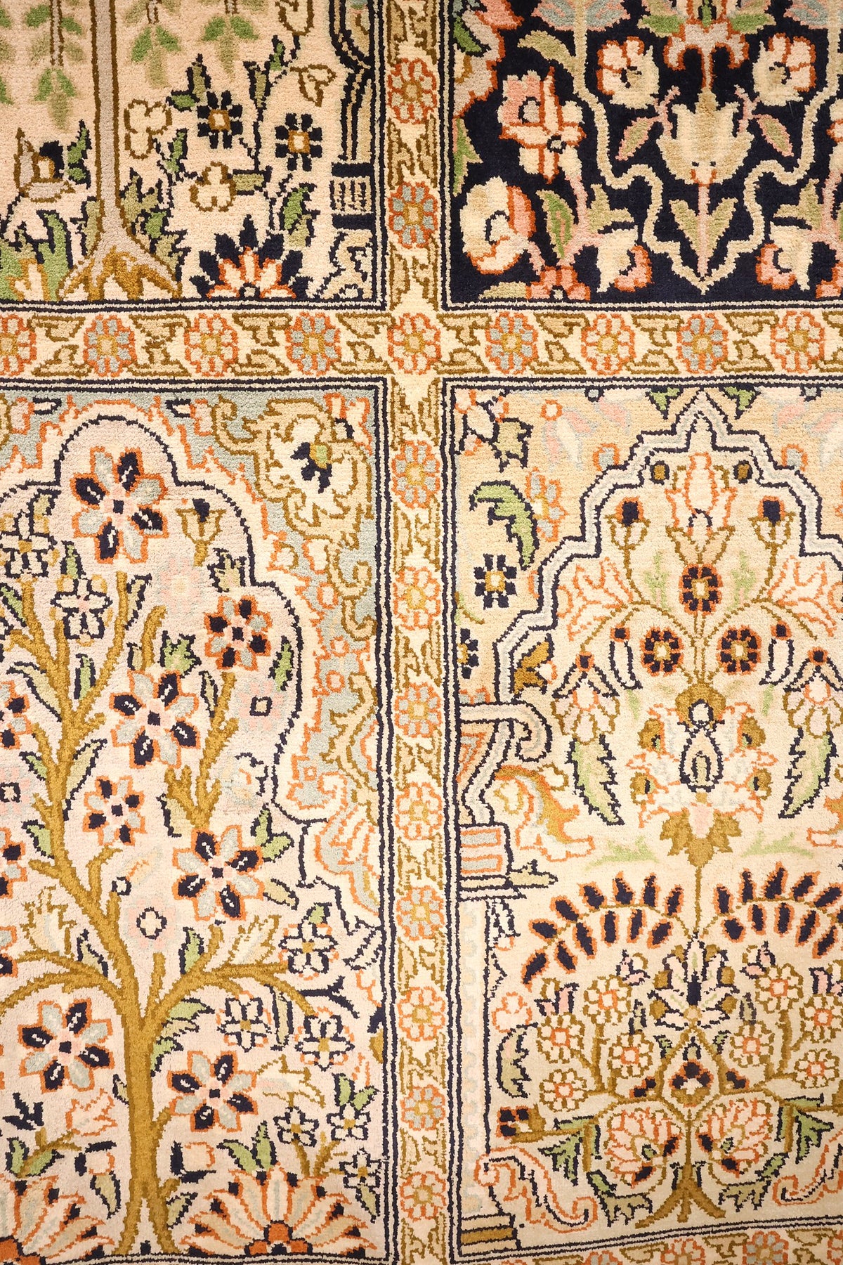 Détail des arbres de vie sur fond ivoire et bleu nuit du tapis Cachemire beige