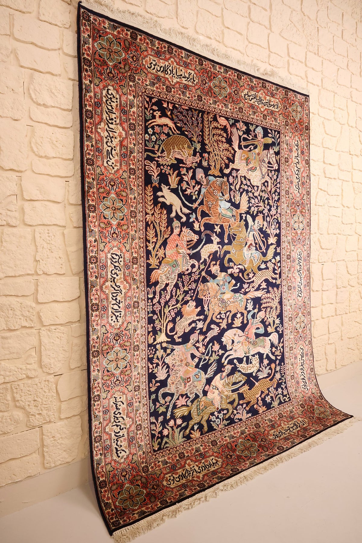 Tapis Cachemire bleu et rose vu de biais, bordure à cartouches inscrits