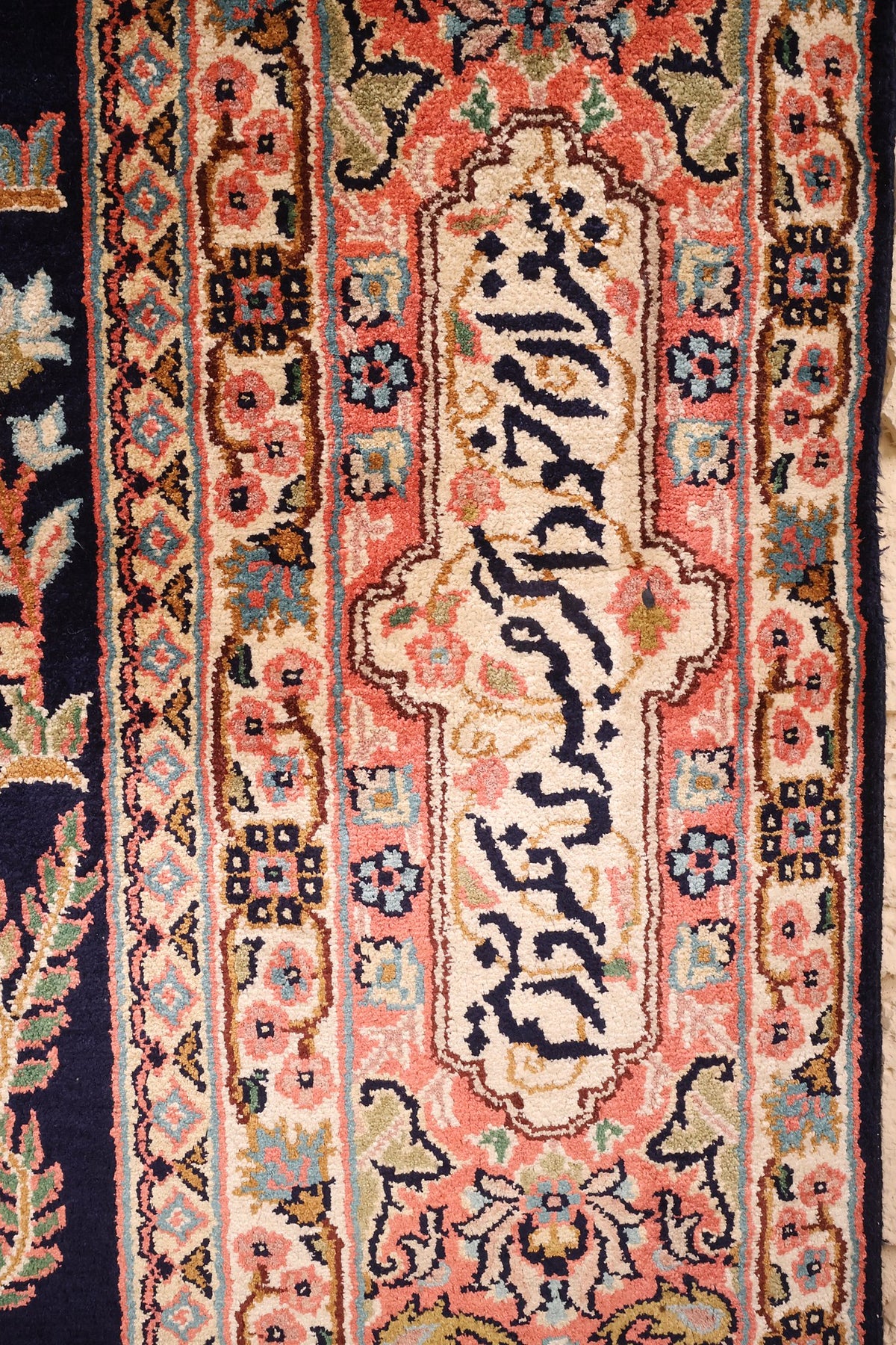Gros plan des caractères arabes et contre-bordures fleuries du tapis Cachemire