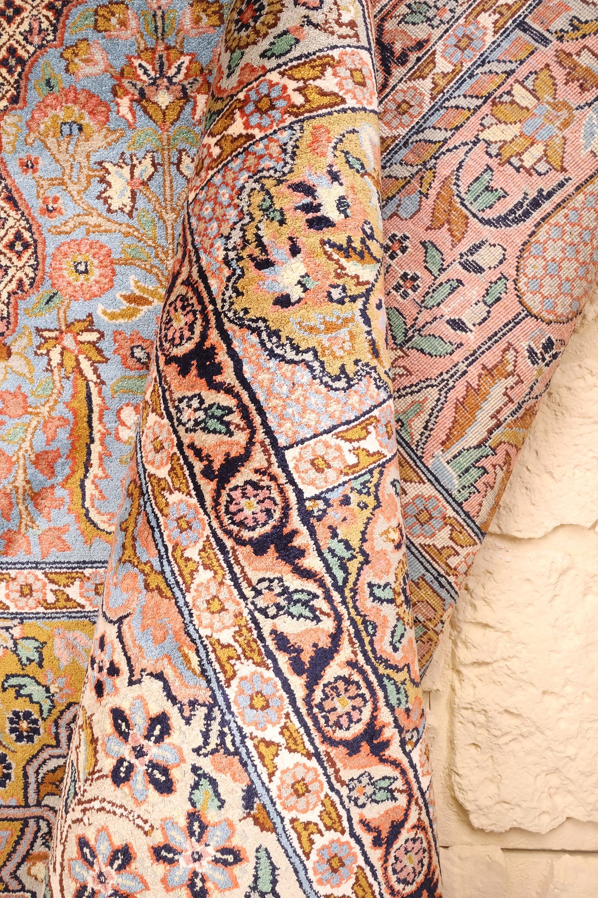 Coin replié du tapis Cachemire, cases bleues et roses le long de la bordure
