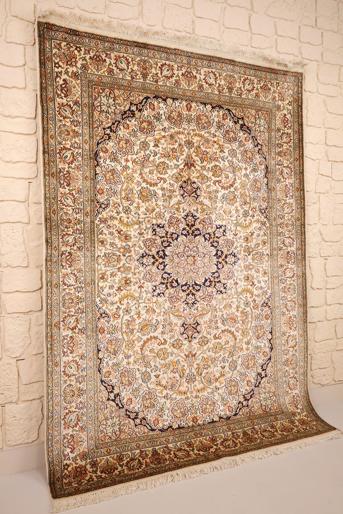 Tapis Cachemire en soie beige et orange, vue de biais montrant les franges claires