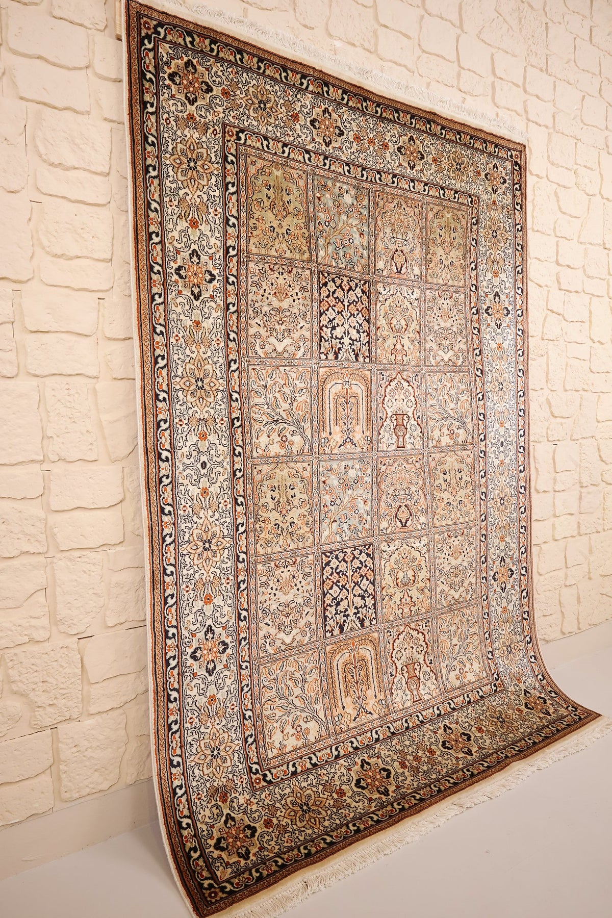 Tapis Cachemire en soie nouée main, vue de biais montrant les franges et la bordure ivoire