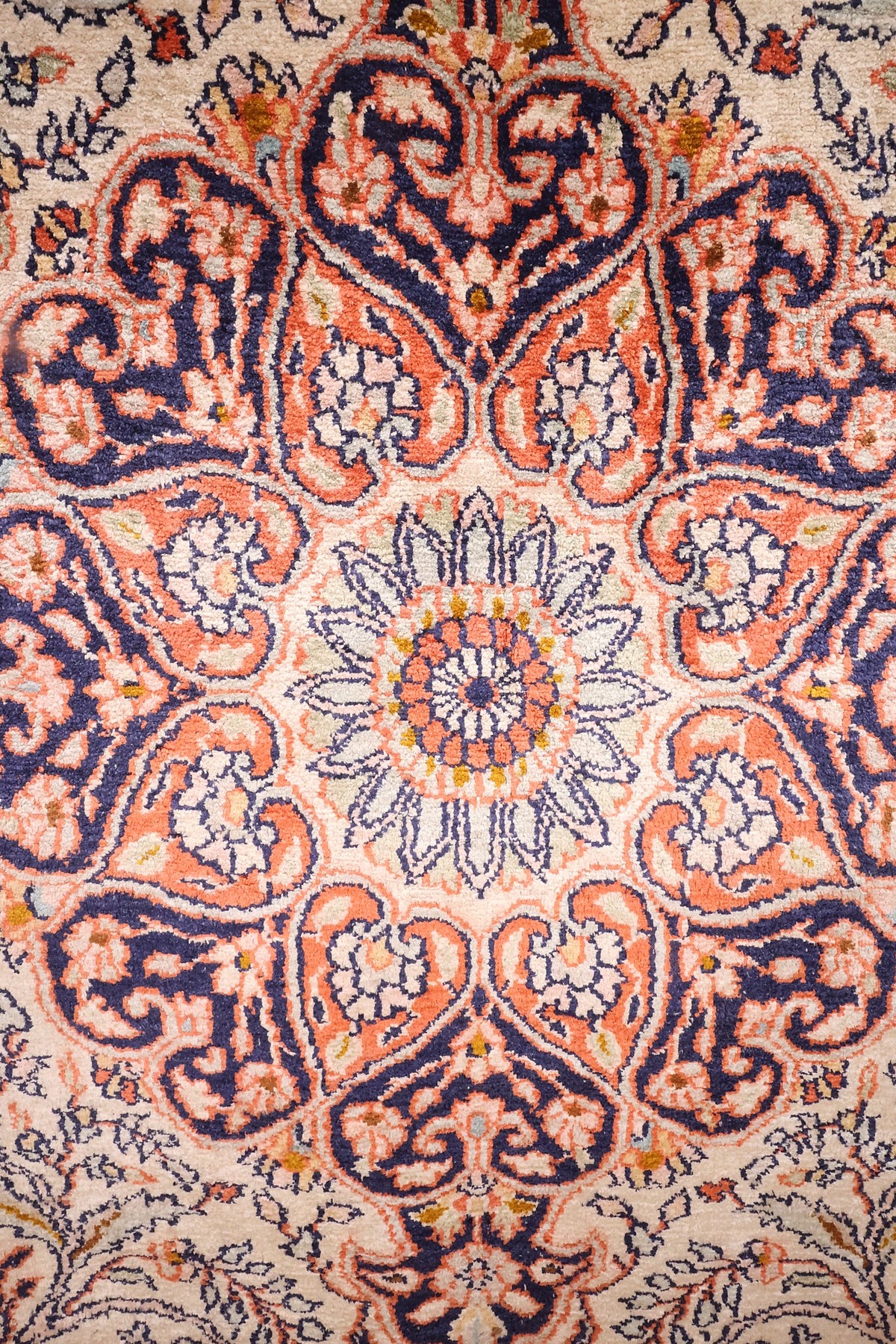 Détail du médaillon en rosace bleu marine et orange du tapis Cachemire