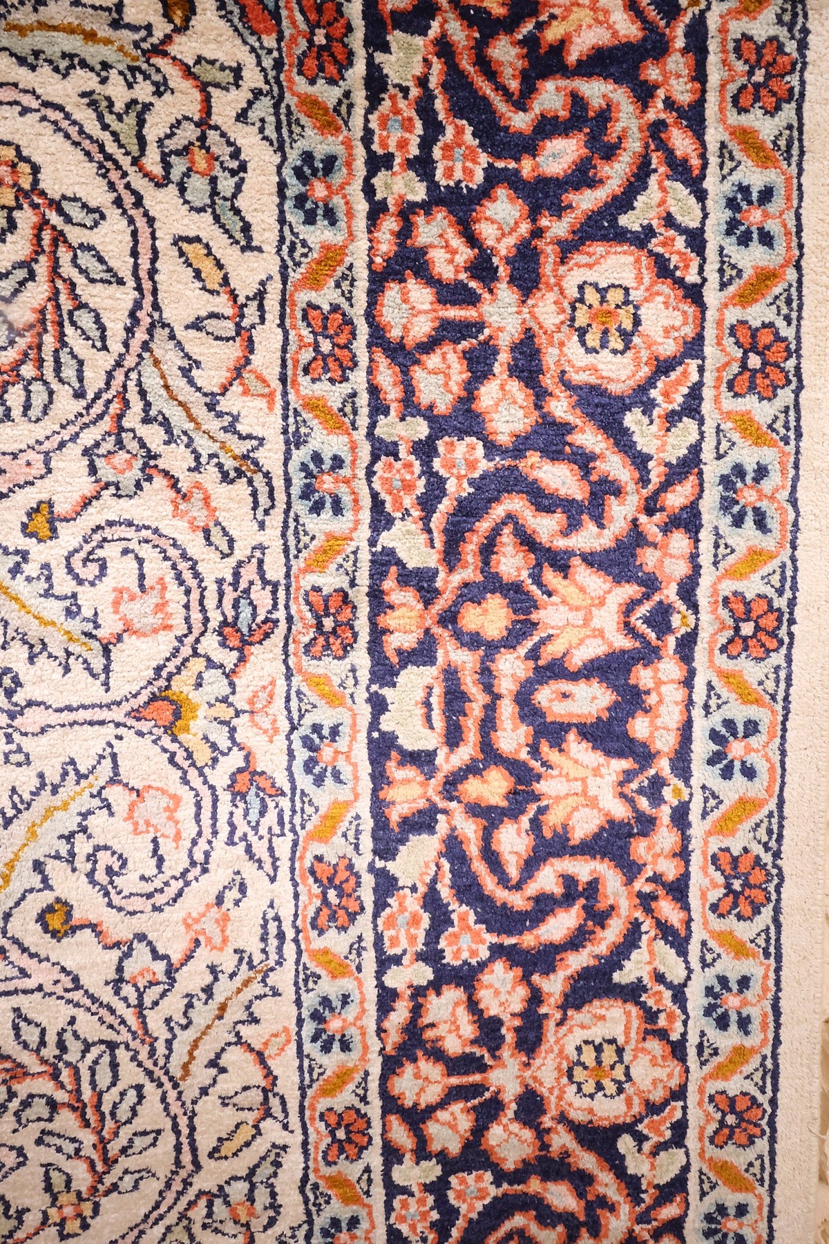 Bordure bleu marine à fleurs orange et contre-bordures claires, tapis Cachemire