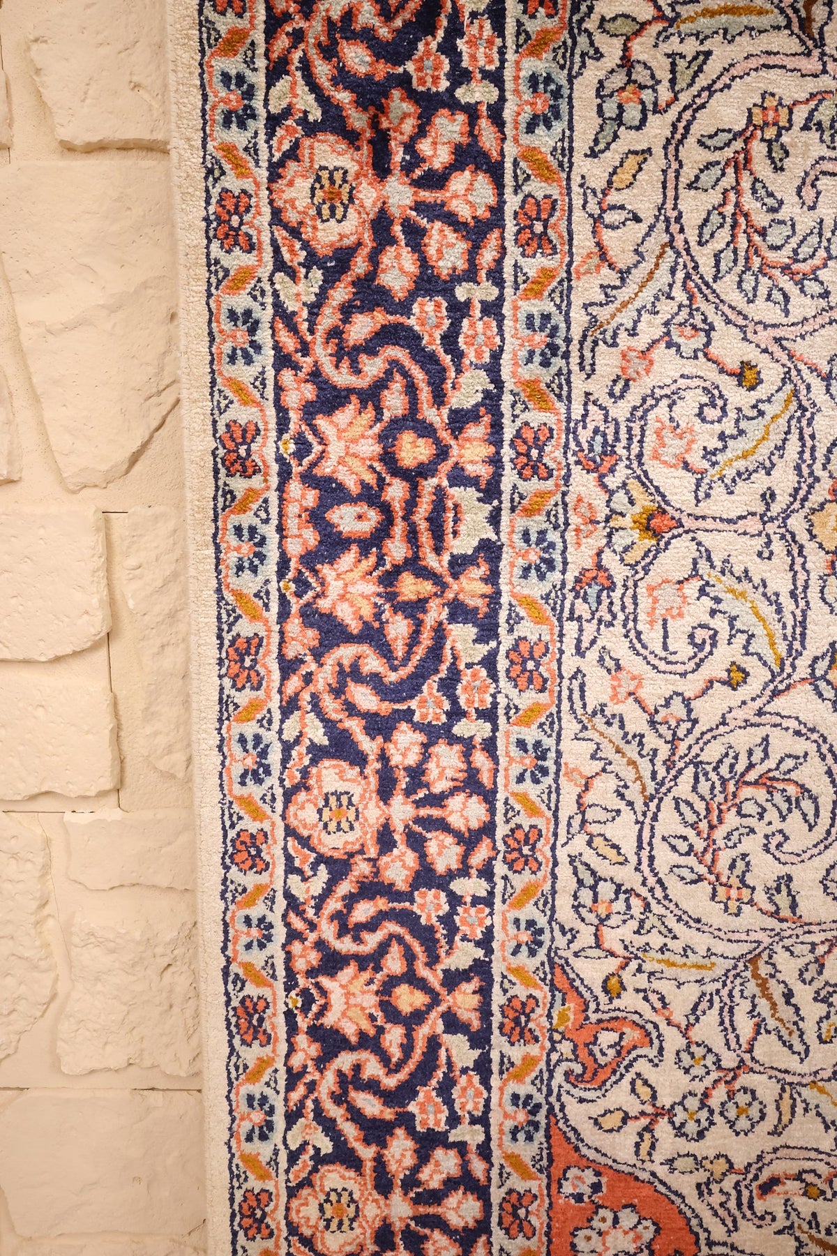 Lisière du tapis Cachemire beige, bordure bleu marine le long du champ ivoire