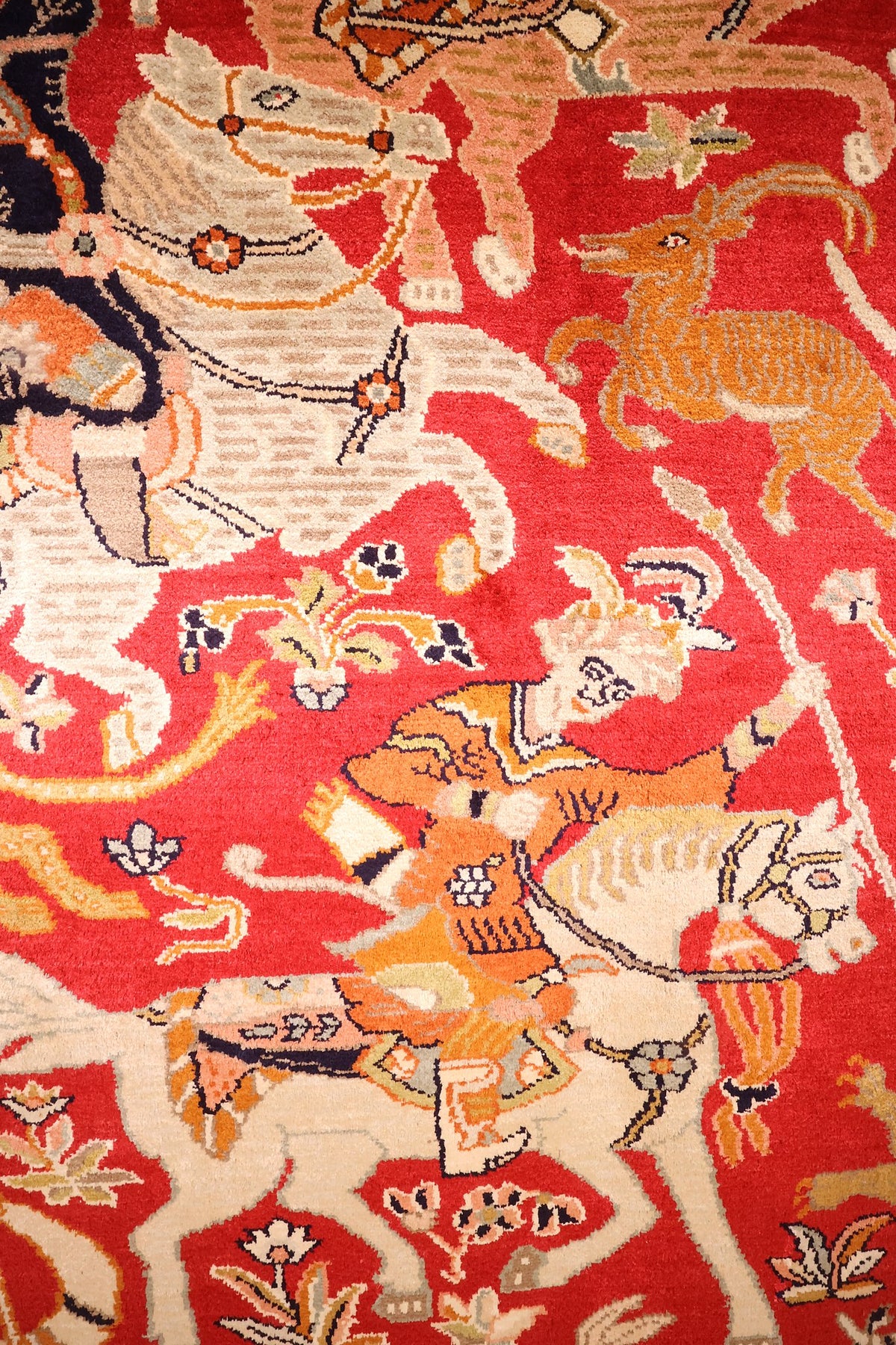 Détail des cavaliers, chevaux et cerf orange du tapis Cachemire rouge