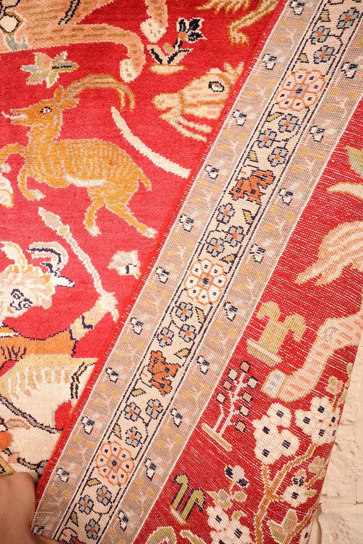 Tapis Cachemire replié : contre-bordures étroites et envers du décor animalier