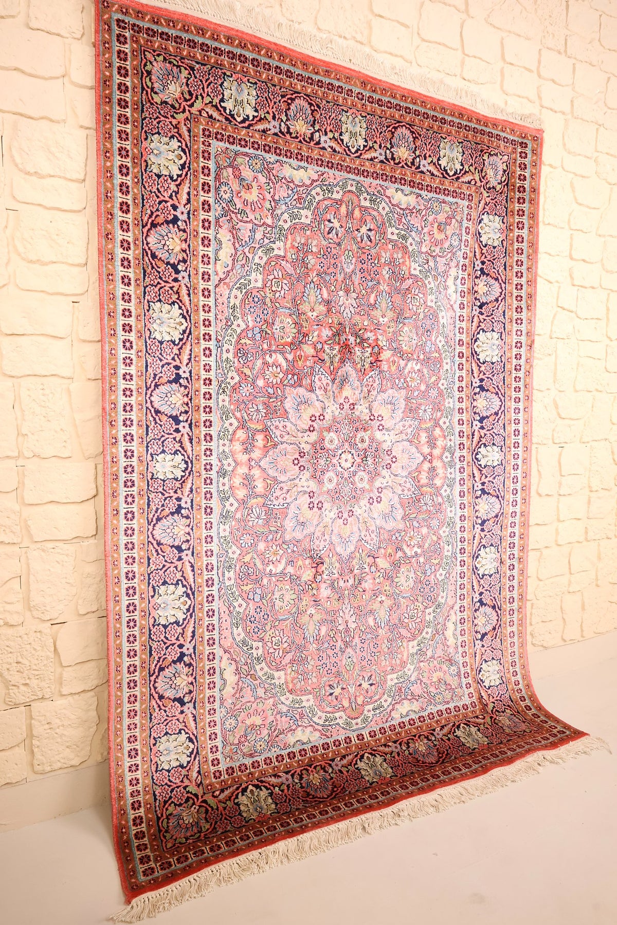 Tapis Cachemire rose et bleu en soie, vue de biais montrant les franges blanches