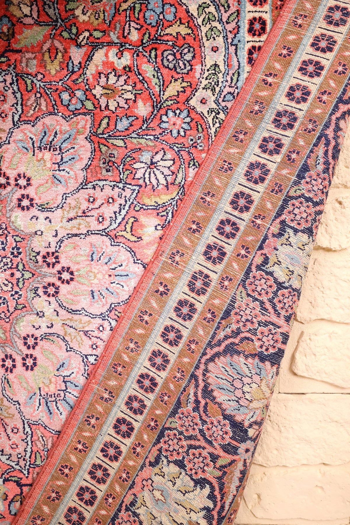 Coin replié du tapis Cachemire en soie, contre-bordures beige et champ corail