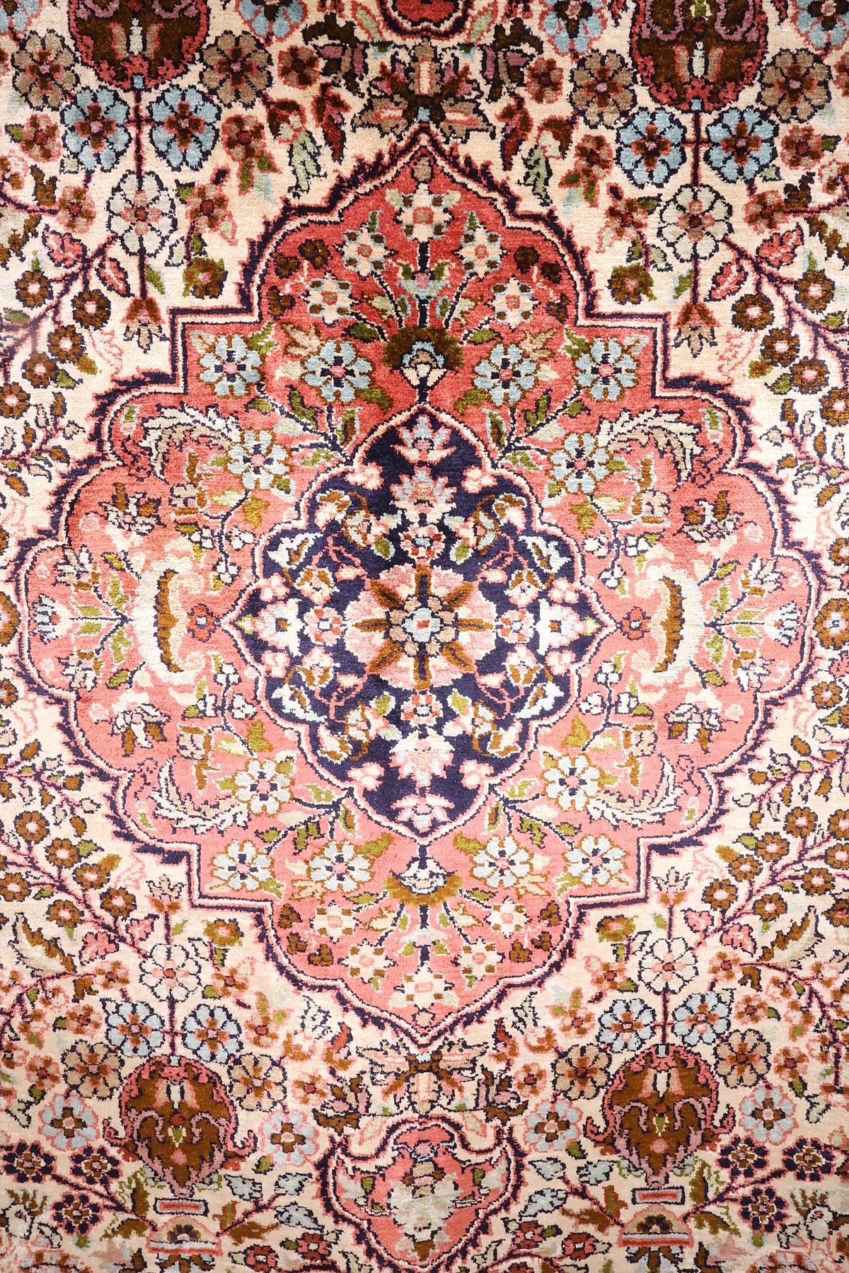 Détail du médaillon rose à cœur bleu nuit du tapis Cachemire en soie
