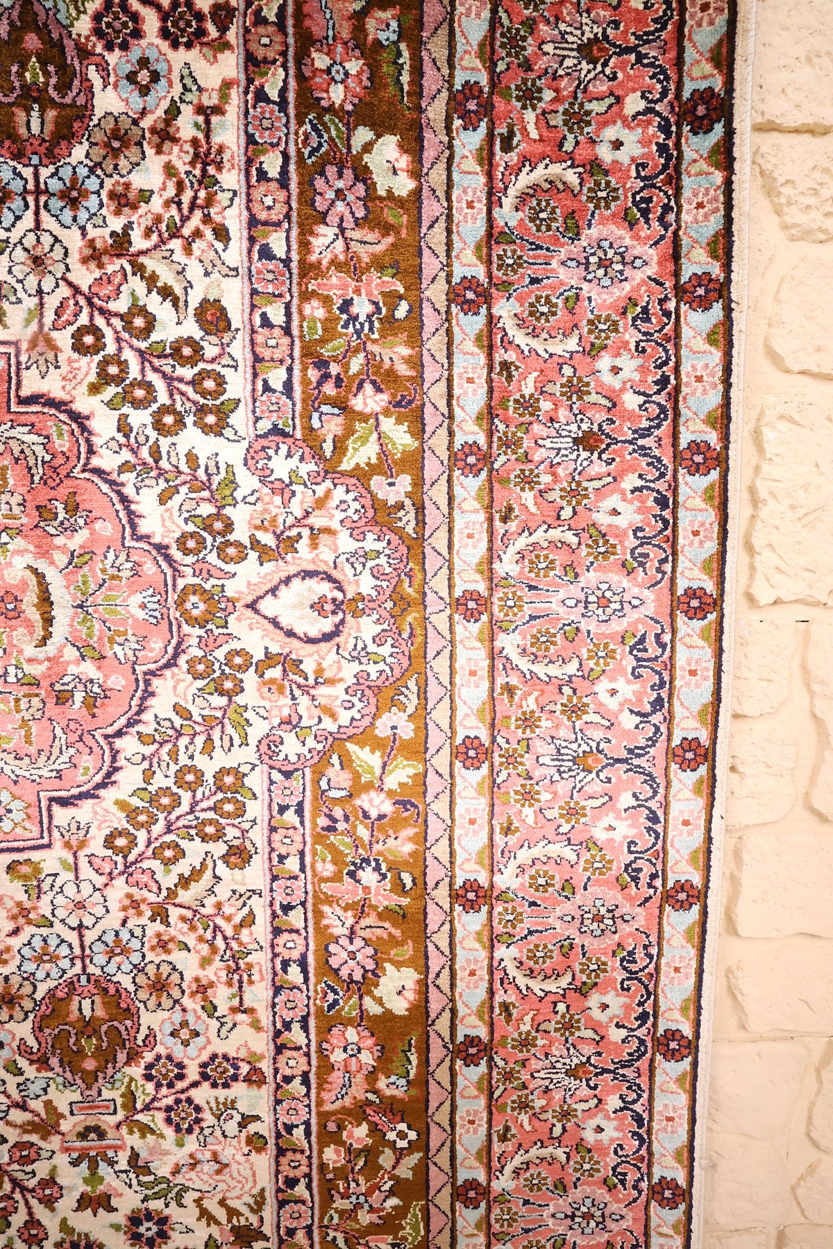 Bordure florale rose, bande marron et galons bleu ciel du tapis Cachemire