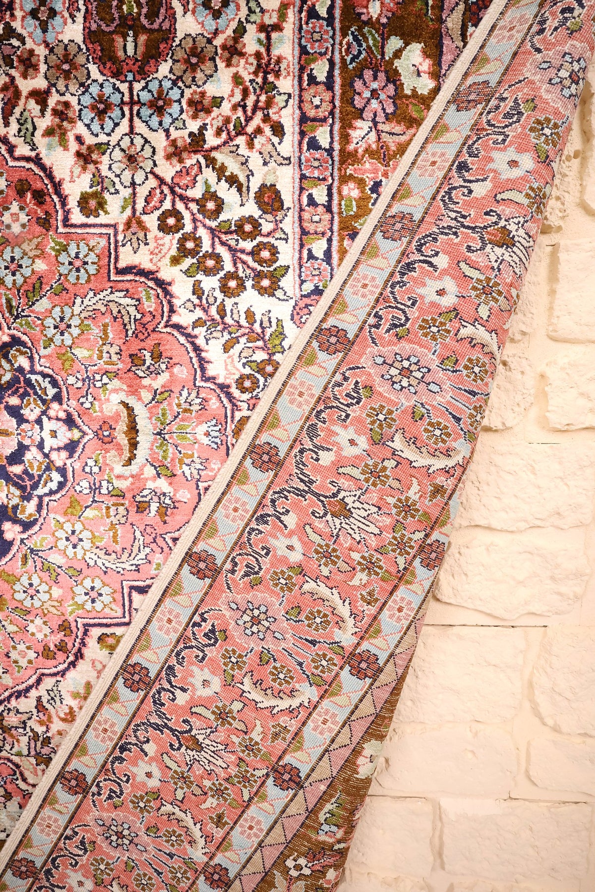 Tapis Cachemire noué à la main, bordure rose en léger relief contre le mur