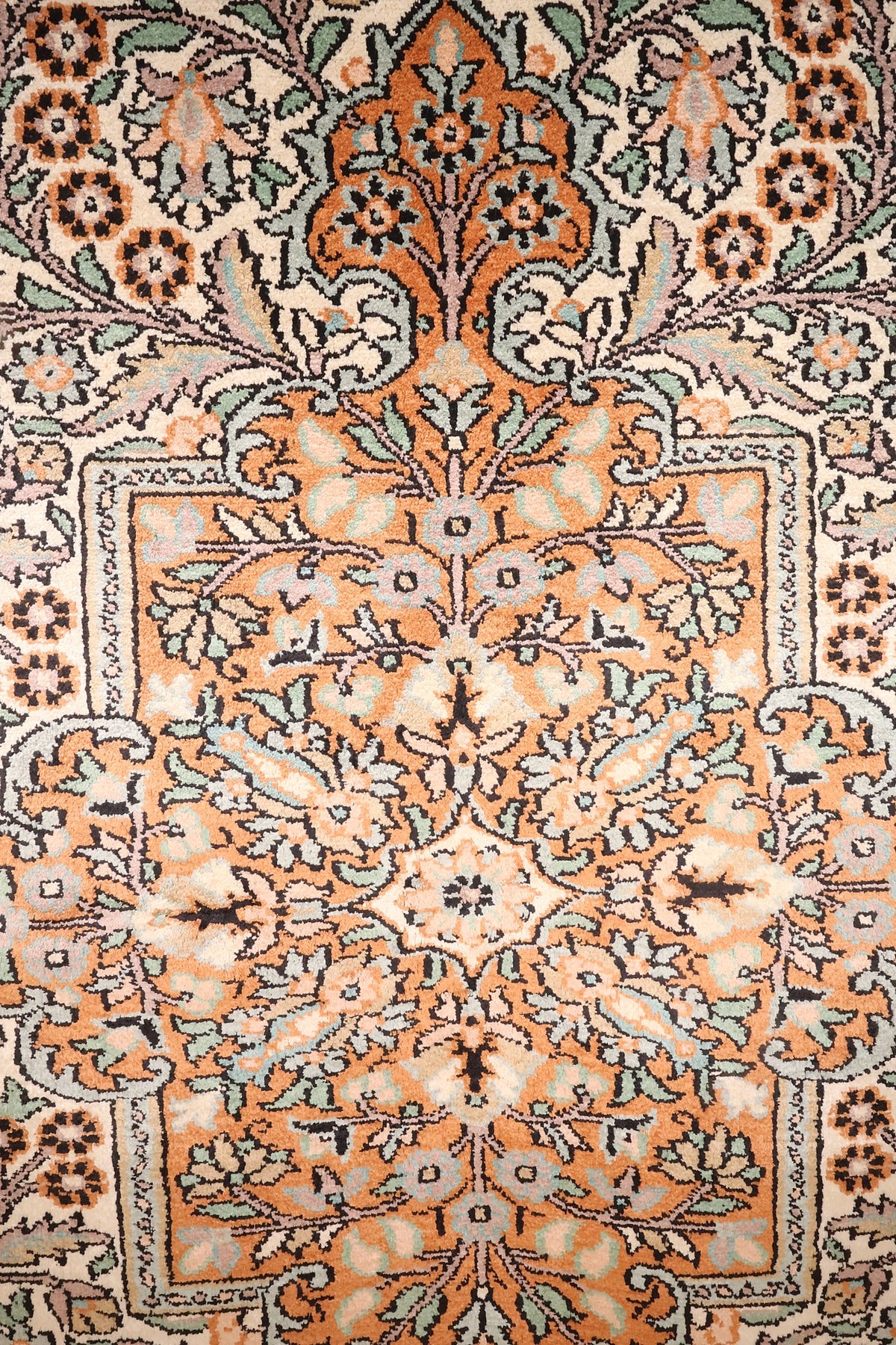 Détail du médaillon orange du tapis Cachemire, rinceaux fleuris et vert d'eau