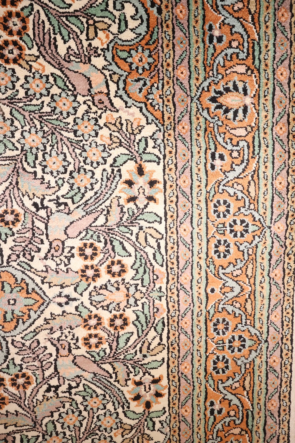 Bordure orange à palmettes et galons étroits du tapis Cachemire beige