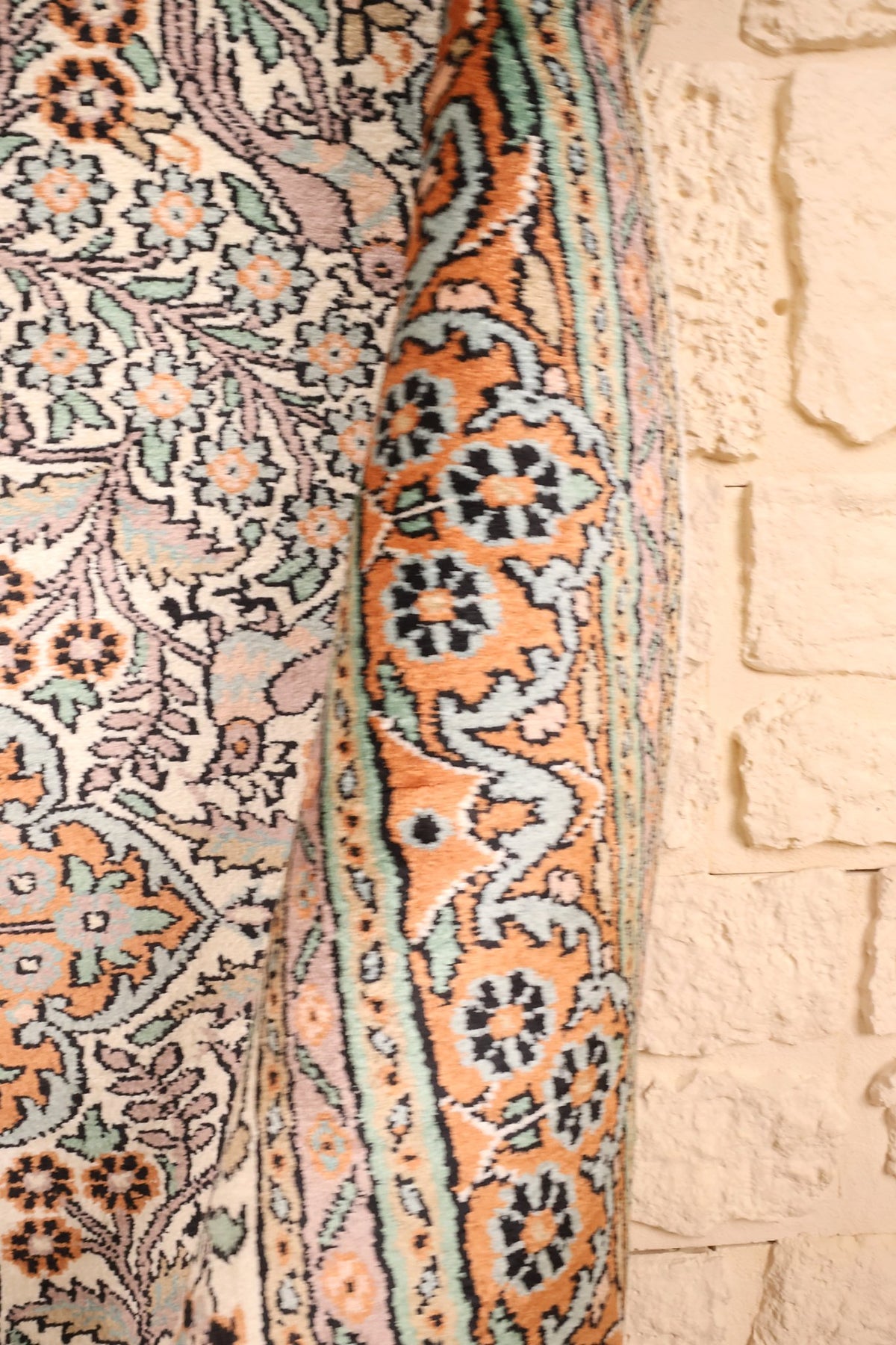 Lisière du tapis Cachemire en soie, bordure orangée et feuillages mauves