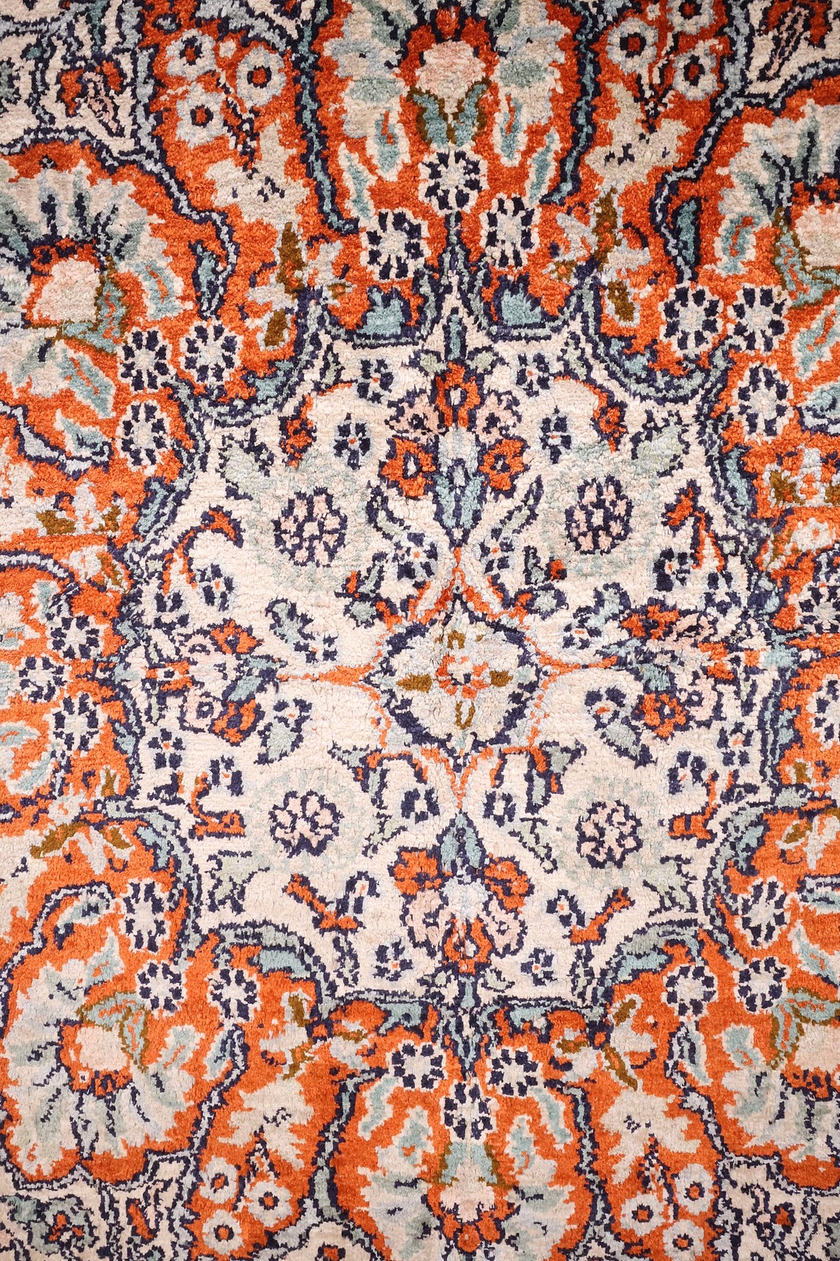 Détail des rinceaux et palmettes orange sur fond ivoire du tapis Cachemire
