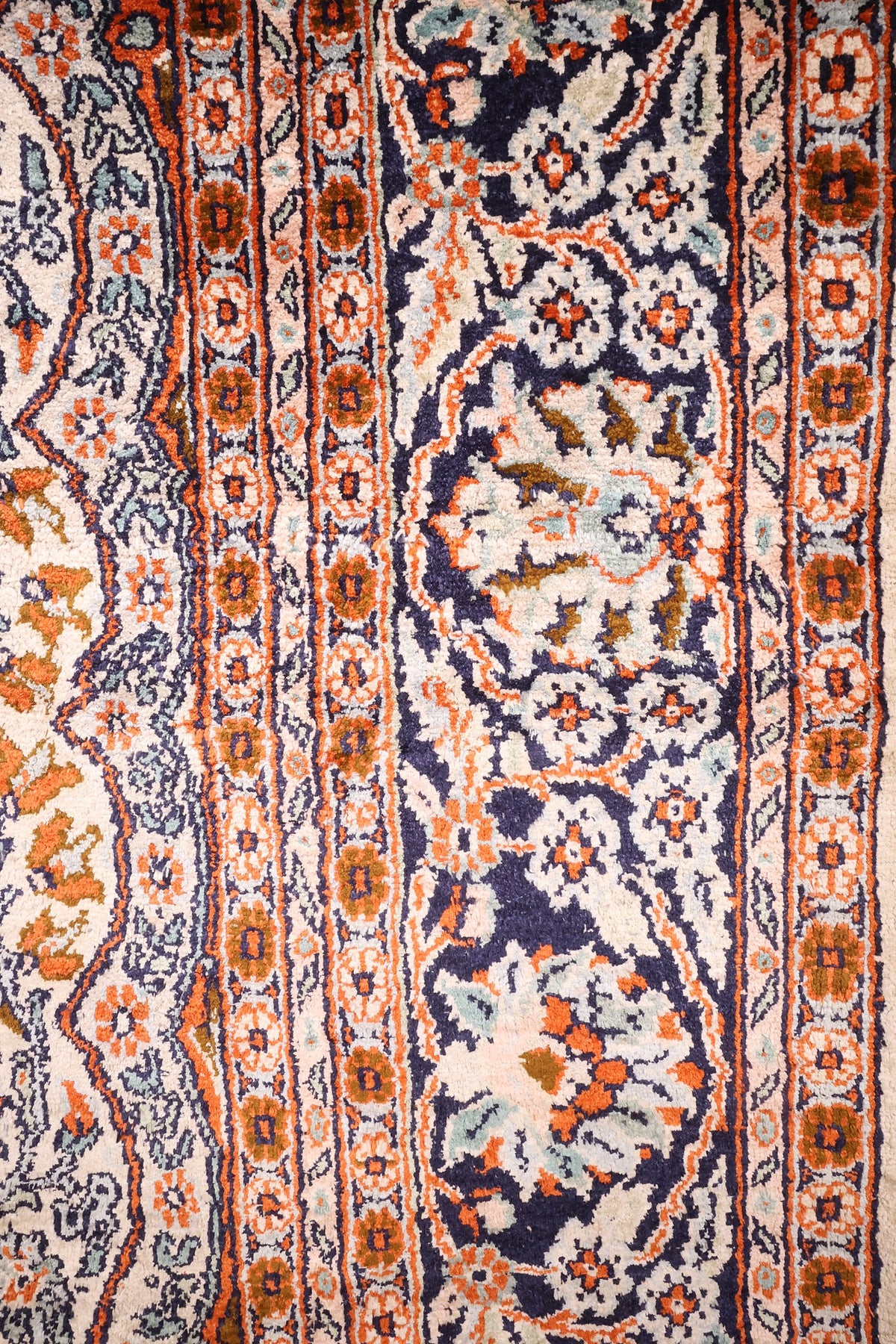 Bordure bleu nuit à guirlande florale et contre-bordures orange du tapis Cachemire